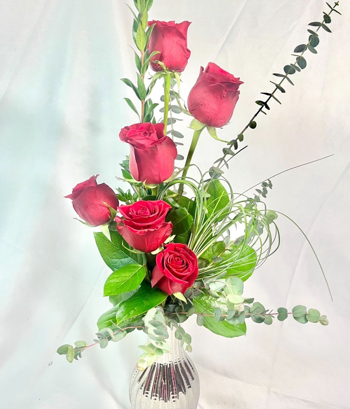 Stunning Red Roses  - In a silver, glass, keepsake vase is a half dozen, hybrid Roses in red.  A stylistic, stunning arrangement sure to wow your love! 