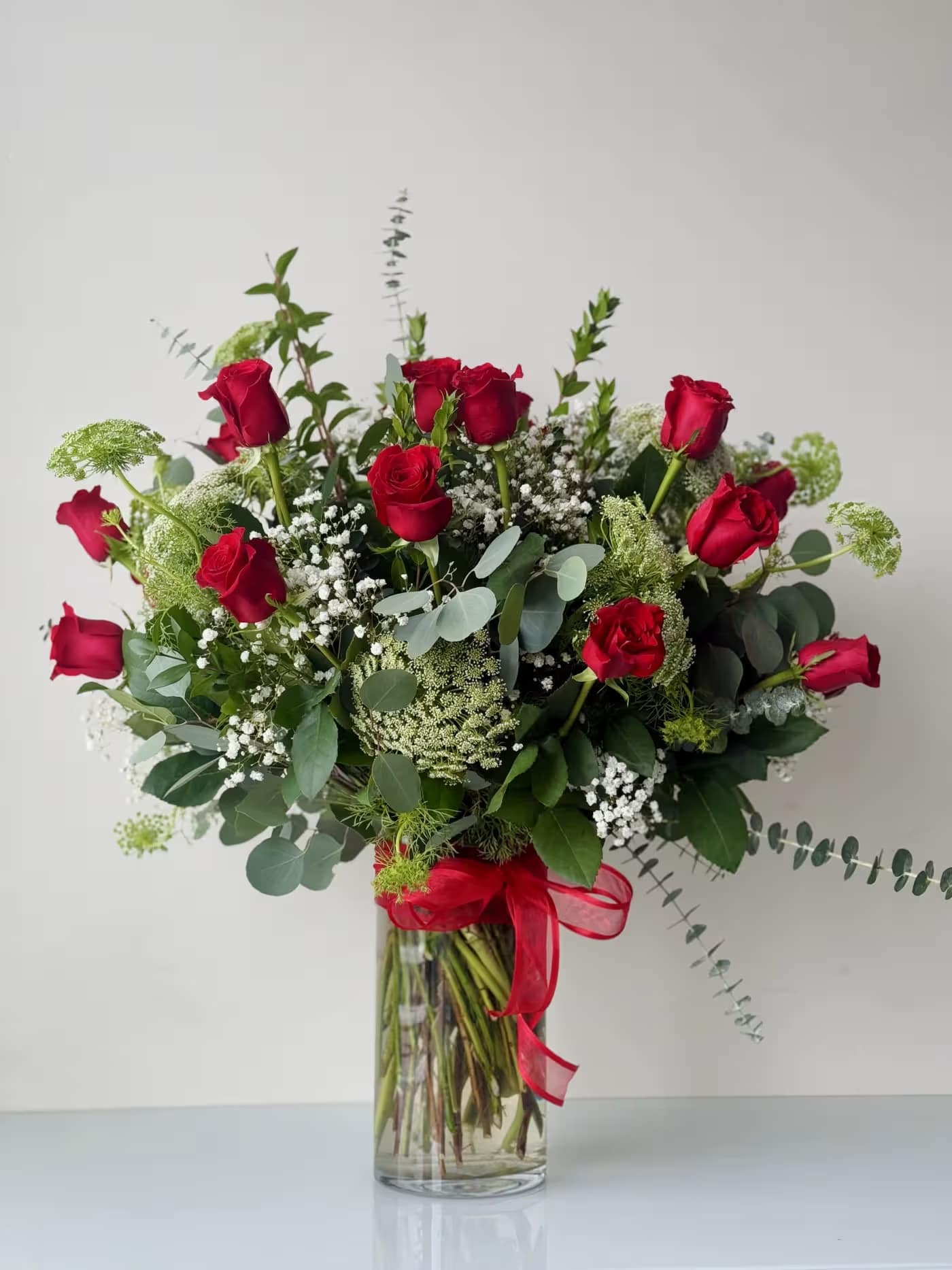 2 Dozen Roses Arrangement Standard 2 Dozen Roses Arrangement Standard - 24 Premium Freedom roses imported from Ecuador, with greens and fillers. Built in a 6”x12” glass vase.