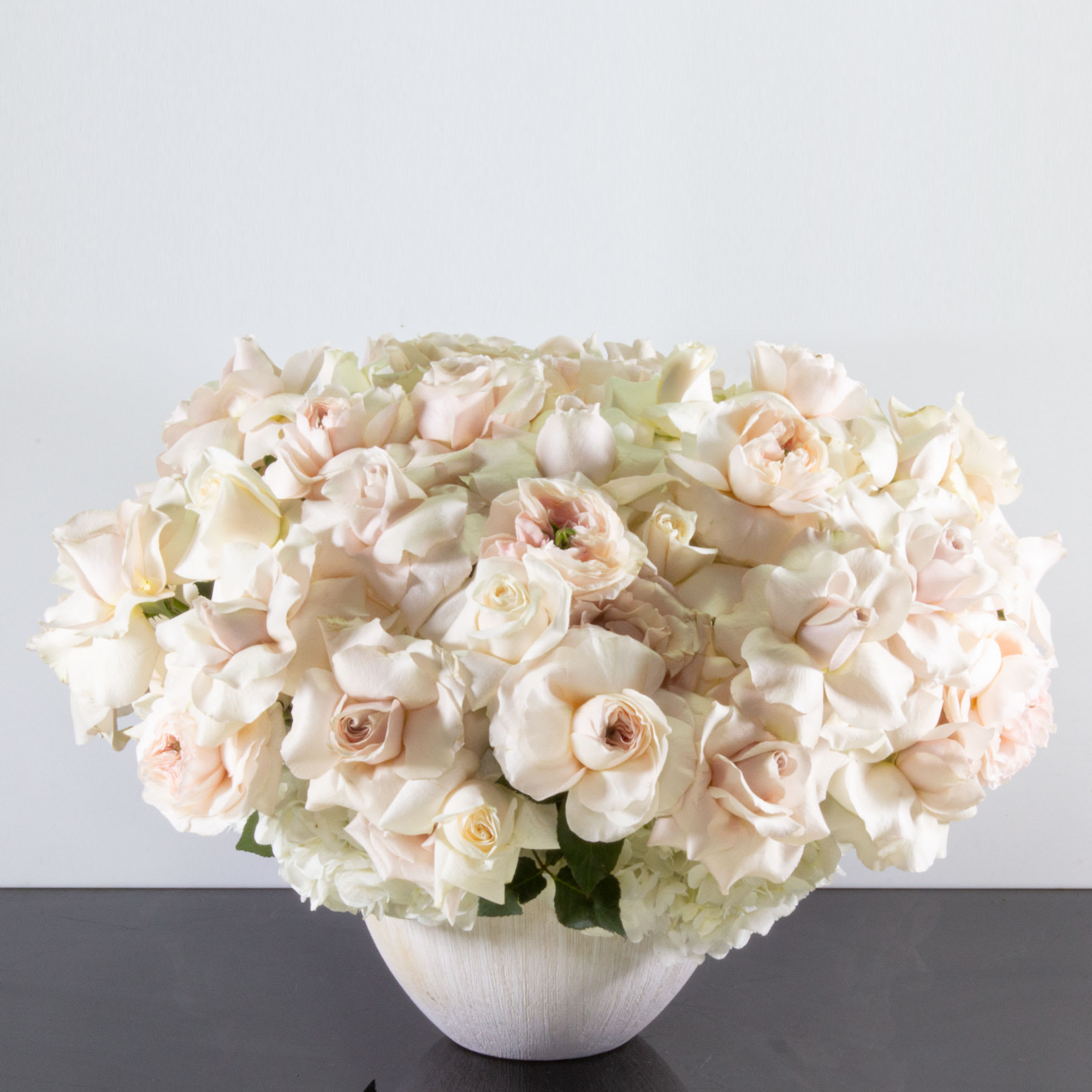 Alluring Elegance - There's nothing quite as alluring and elegant as this sweetly scented bouquet for your special someone. This lovely arrangement features deeply fragrant mix of 100 Pale Pink and Cream Roses accented by White Hydrangeas. A sophisticated choice for any celebration, gift, or for your own home.  Deluxe: 150 Pale Pink and Cream Roses  Premium: 200 Pale Pink and Cream Roses