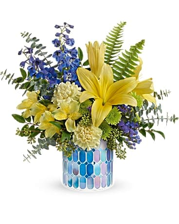 Teleflora's Seaside Sunshine Bouquet Teleflora's Seaside Sunshine Bouquet - As invigorating as a walk along the ocean, this special springtime surprise features a sunshiney bouquet in a beautiful blue stained glass mosaic vase. This bright arrangement includes yellow asiatic lilies, yellow alstroemeria, yellow carnations, blue delphinium, green button spray chrysanthemums, blue sinuata statice, sword fern, spiral eucalyptus, seeded eucalyptus and huckleberry. Delivered in a Blue Beauty Mosaic vase.