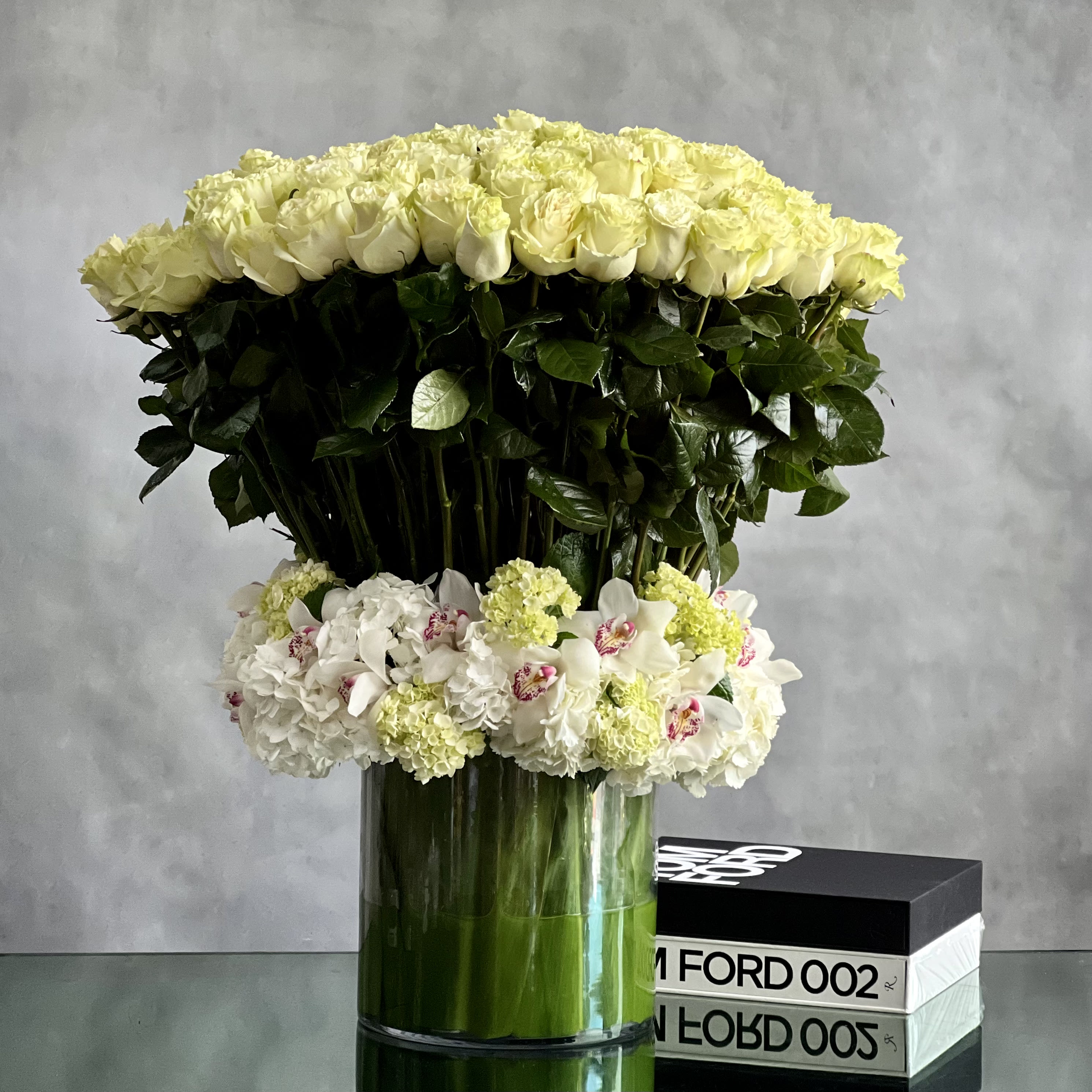 White Heaven - Valentines Edition - Want to make today a heavenly one for someone you know? White roses are a symbol of purity, peace, and serenity. This premium bouquet of 200 white roses nested with white hydrangeas and white cymbidium orchids in a  leaf lined glass vase This huge and grand floral arrangement to send for weddings anniversaries, sympathy or just to let someone know you are thinking of them.      