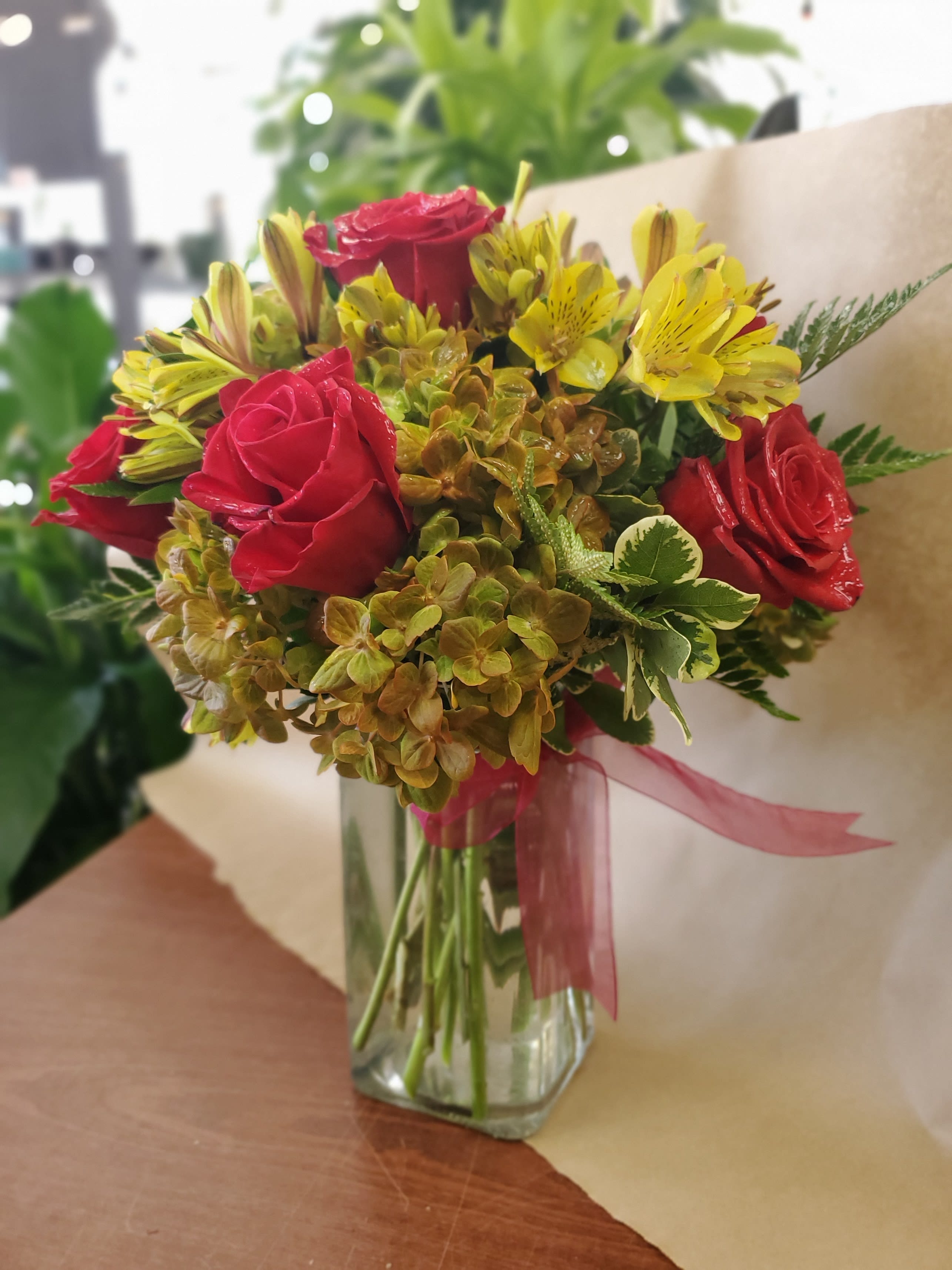 Olive Whimsy - A unique and colorful arrangement sure to please anyone. We'll include hydrangea, alstroemeria, and fresh roses in this arrangement topped off with a matching bow.