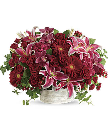 Stunning Statement Bouquet - Brimming with hydrangea, orchids, roses and lilies in fabulous fuchsias and radiant reds, this breathtaking bouquet definitely makes a statement! This stunning arrangement of red hydrangea, red cymbidium orchid blossoms, red roses, red spray roses, hot pink oriental lilies, red gerberas, and red hypericum is accented with green ivy and lemon leaf. Delivered in a white cylinder planter.