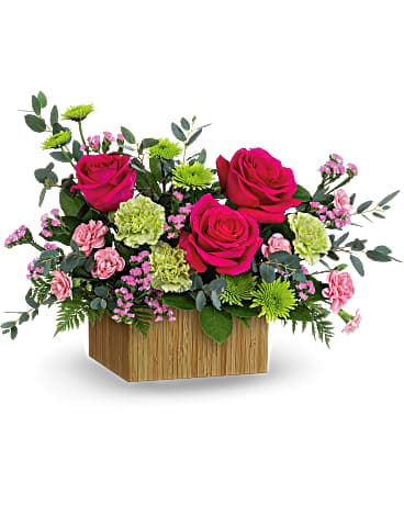 Teleflora's Chasing Sunsets Bouquet - As beautiful as a summer sunset, this bright bouquet of roses and mums in a modern bamboo cube radiates joy! This colorful gift includes hot pink roses, green carnations, miniature pink carnations, green cushion spray chrysanthemums, pink sinuata statice, parvifolia eucalyptus, lemon leaf and leatherleaf fern. Delivered in a Small Bamboo Rectangle container.