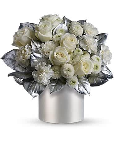 Teleflora's Elegant Evening - When the occasion requires elegance, you need look no further than this fabulous bouquet that's all dressed up in winter whites and silver. Stunning white roses, carnations and chrysanthemums are exquisitely arranged with silver painted salal stems in a silvery, satiny cylinder vase. The evening and the arrangement will be ones to remember!
