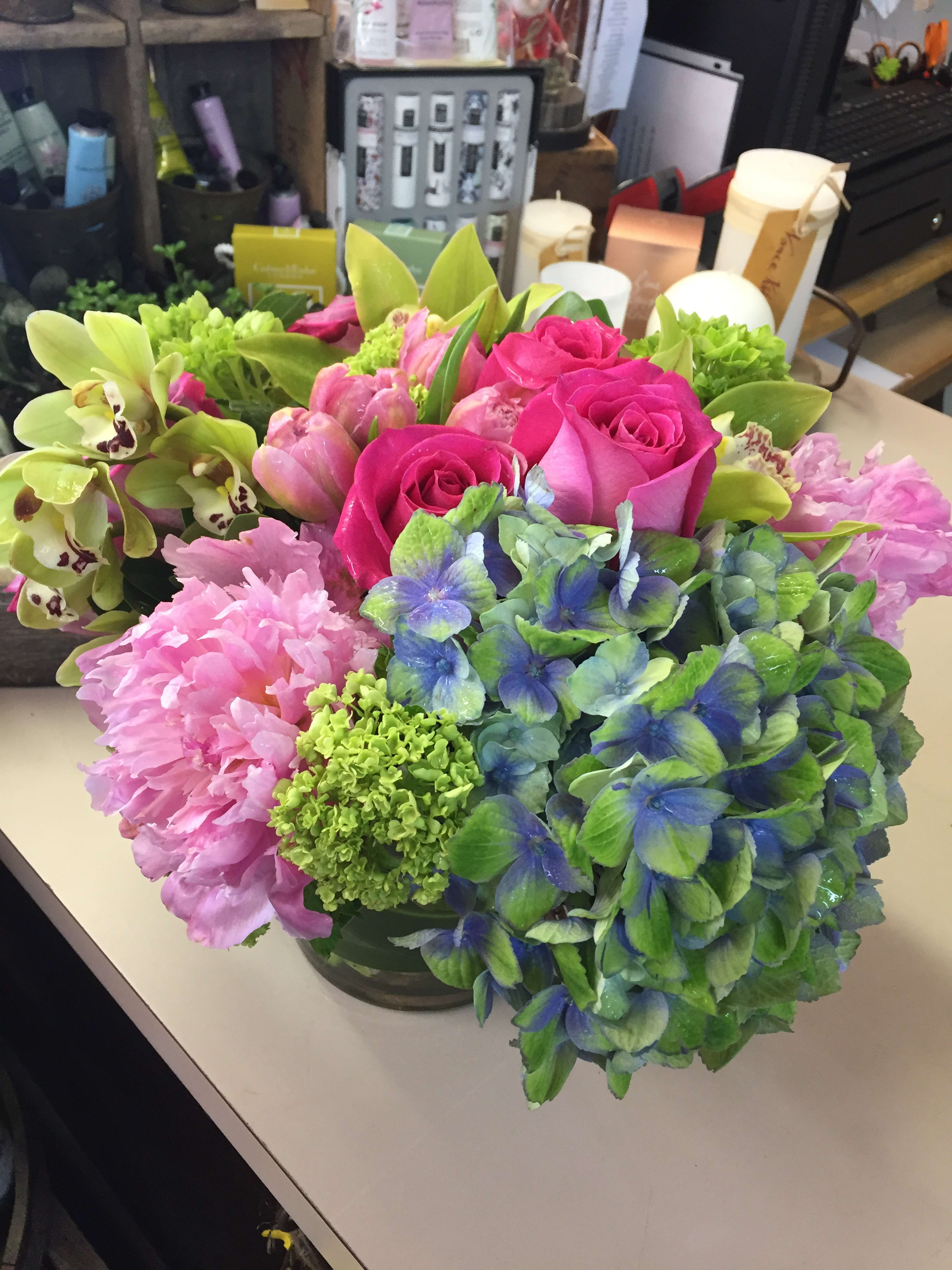 Happy Hydrangea - Cymbidium orchids, tulips. hot pink roses compliment funky hydrangea. Colors may vary toward purple or pink on hydrangea depending on availability