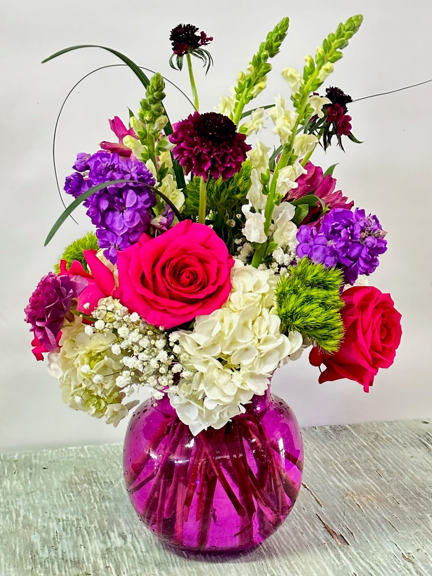 Mother's Day #7 Mother's Day #7 - Arrangement of fresh cut flowers designed in a pink glass vase. PLEASE NOTE: ARRANGEMENT WILL BE MADE AS SIMILAR AS POSSIBLE TO THE IMAGE YOU SEE. DUE TO HIGH DEMAND ALL FLOWERS MAY NOT BE AVAILABLE AND MAY BE SUBSTITUTED TO KEEP COLOR SCHEME AND STYLE AS SIMILAR AS POSSIBLE.