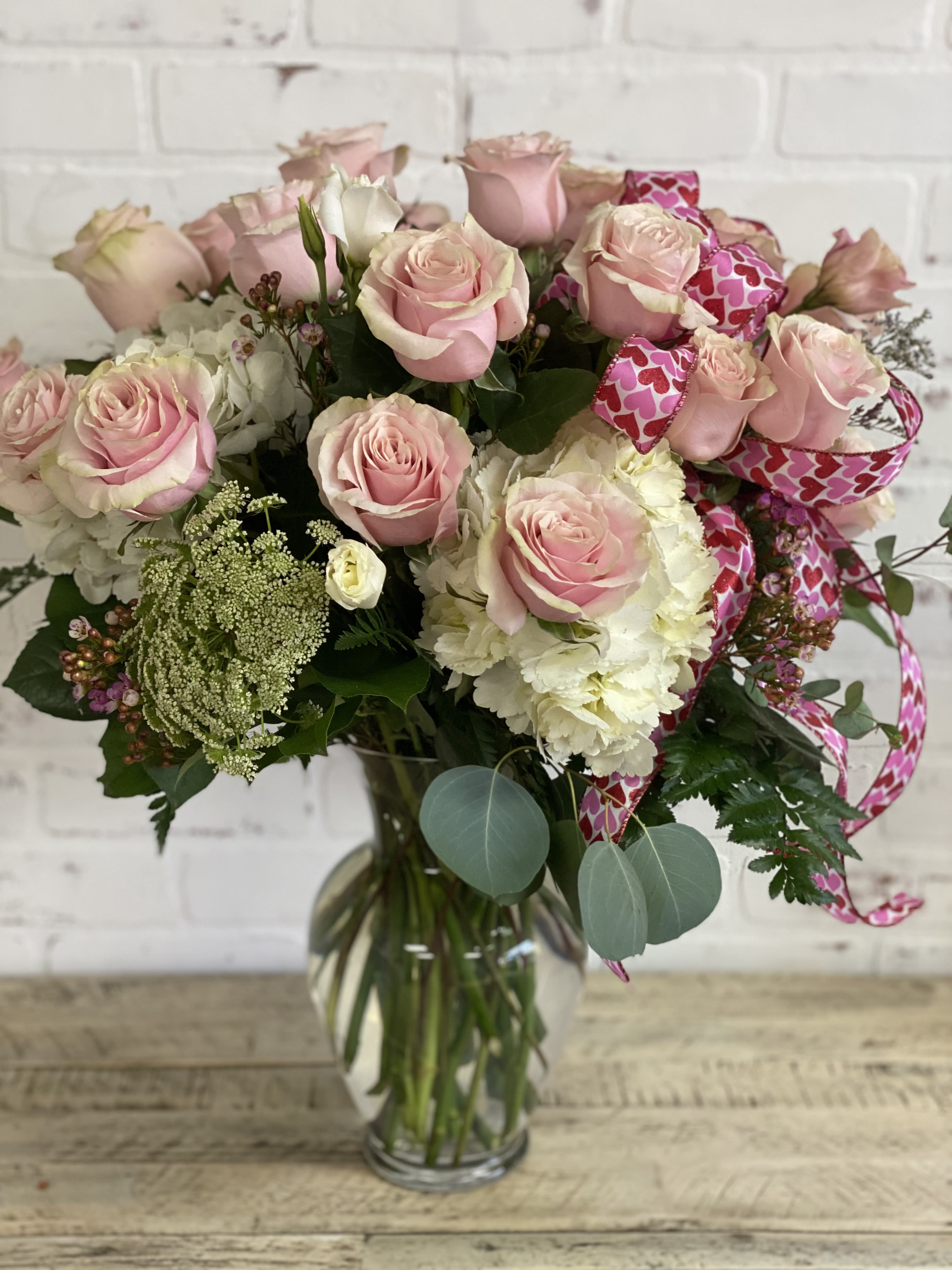 Mondial Pink - Over a dozen pink mondial roses with hydrangea and filler flowers