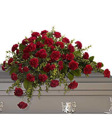 Adoration Casket Spray - With dignity and grace, brilliant red carnations express the depth of your heartfelt feelings, and the tenderness of your everlasting devotion. A classic half-couch spray of red carnations set against oregonia and salal, perfectly fitting for an open or closed casket service. Orientation: N/A  SUBSTITUTION POLICY – Always deliver the freshest flowers! Please note the bouquet pictured reflects our original design.  If the exact flowers or container in this arrangement are not available, our local florists will create a beautiful bouquet with the freshest available flowers.