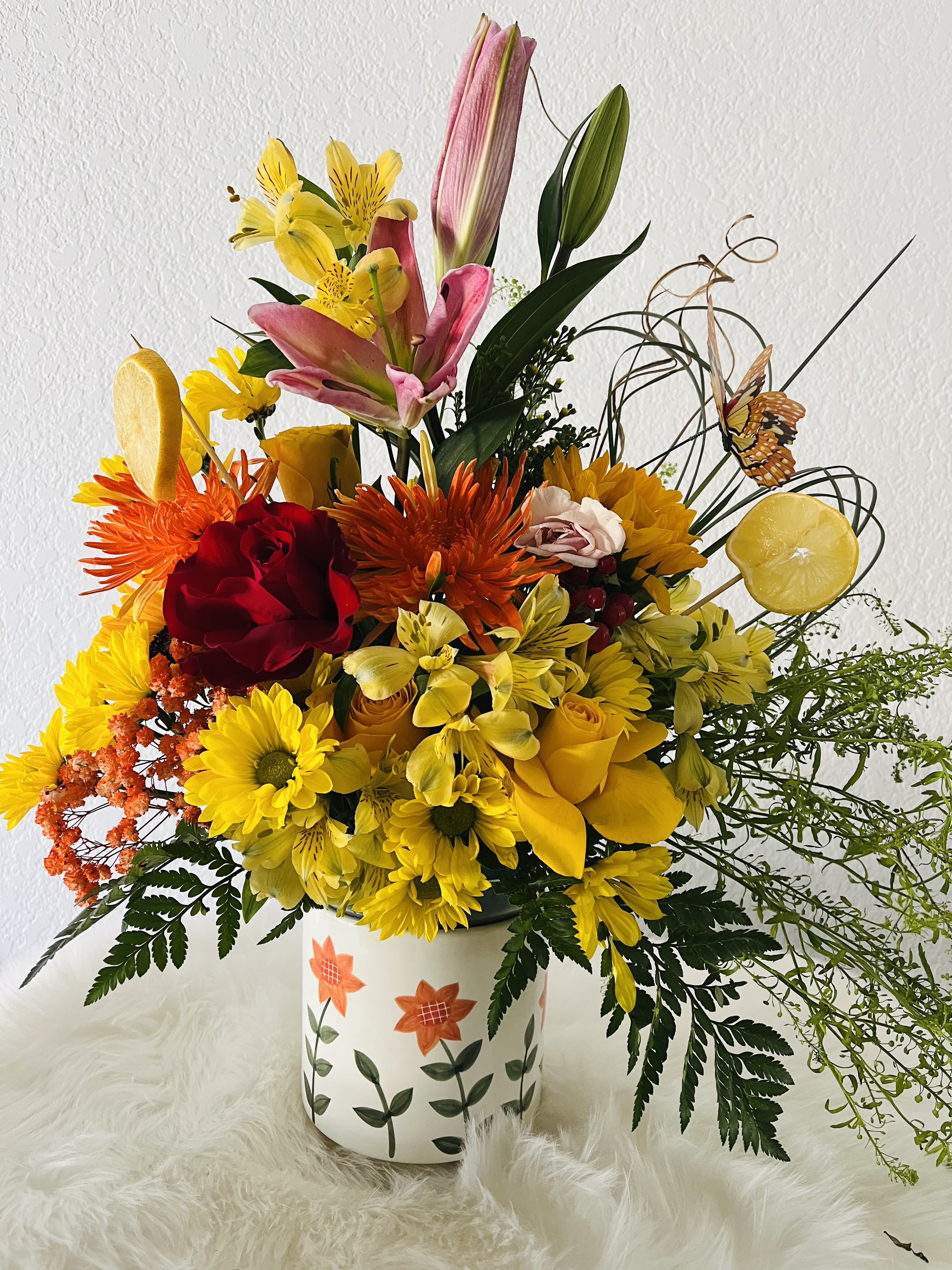 Scarecrow - A colorful floral arrangement of seasonal flowers in a decorated ceramic container, perfect for any gift giving occasion. Send smiles to your loved ones.