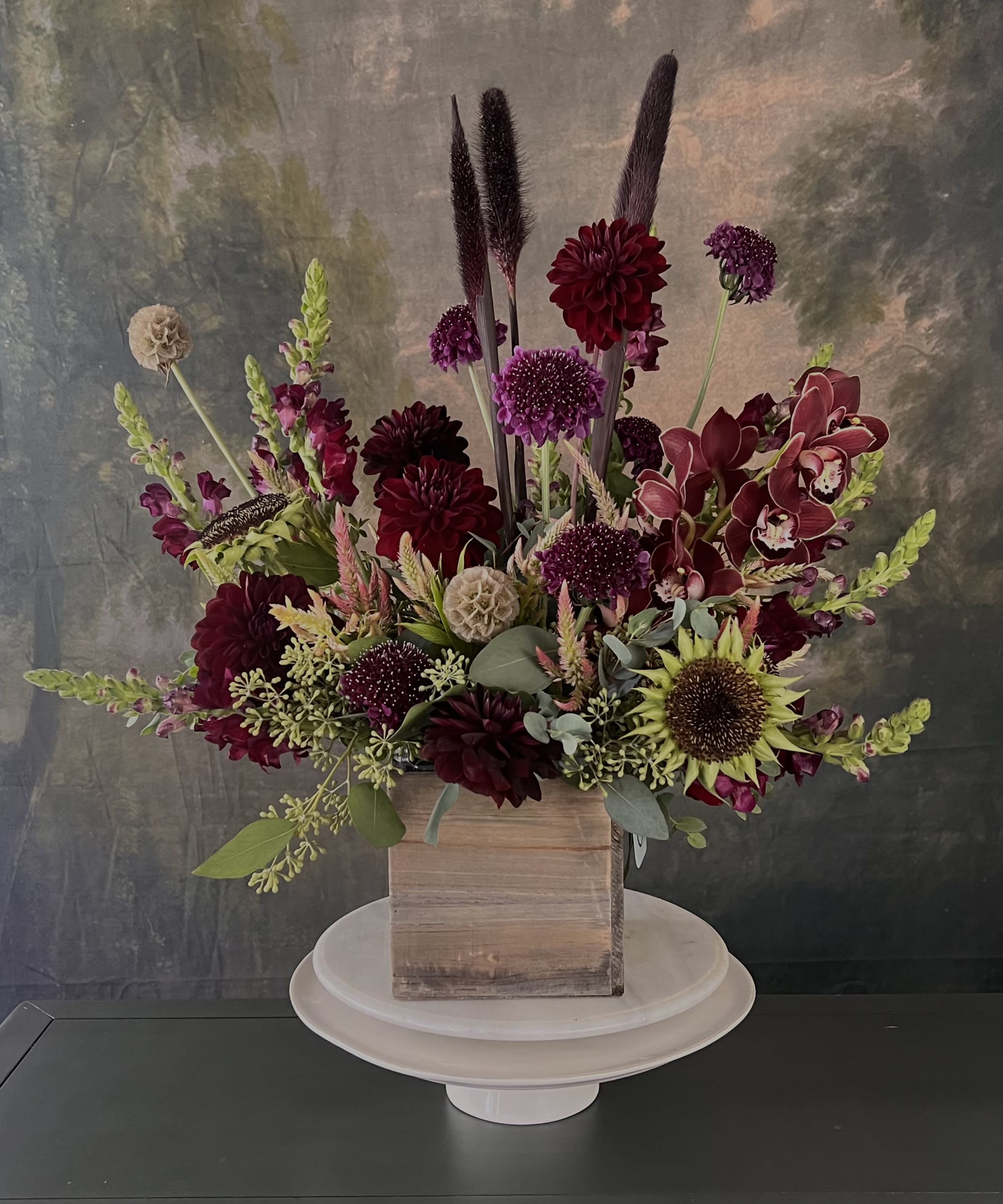 Amber - This dark and moody arrangement features a unique collection of seasonal florals, dried materials, and botanicals, brought together in a high end ceramic vase. Perfect for surprising that special someone, this design is one of our absolute favorites!  Flowers and greenery may vary due to seasonal availability, but that’s part of the charm! Our creative designers will substitute with the freshest high end product available- some grown in our very own garden!- and create something beautiful.  *Have a special request?* Let us know in the special instructions section during checkout.