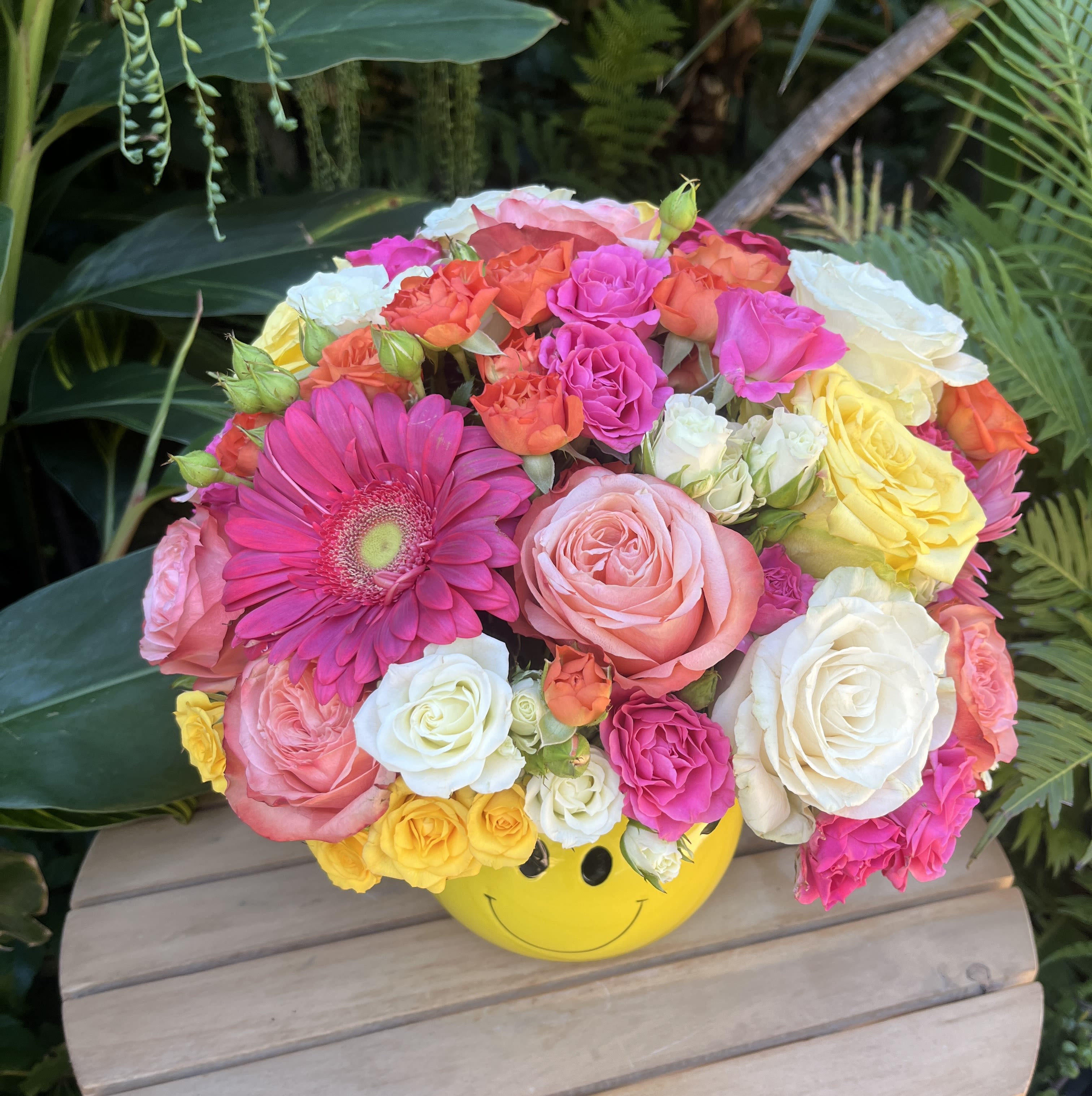 Smiling  - Hand-crafted mixed flower bouquet in a smiley face vase. Each purchased arrangement may differ from the photo due to natural variability in the shape and coloration of natural blossoms. If you would like to request specific flower types and colors, please place your order in the Custom Arrangements section where you can specify those details or give us a call to discuss your ideas. 