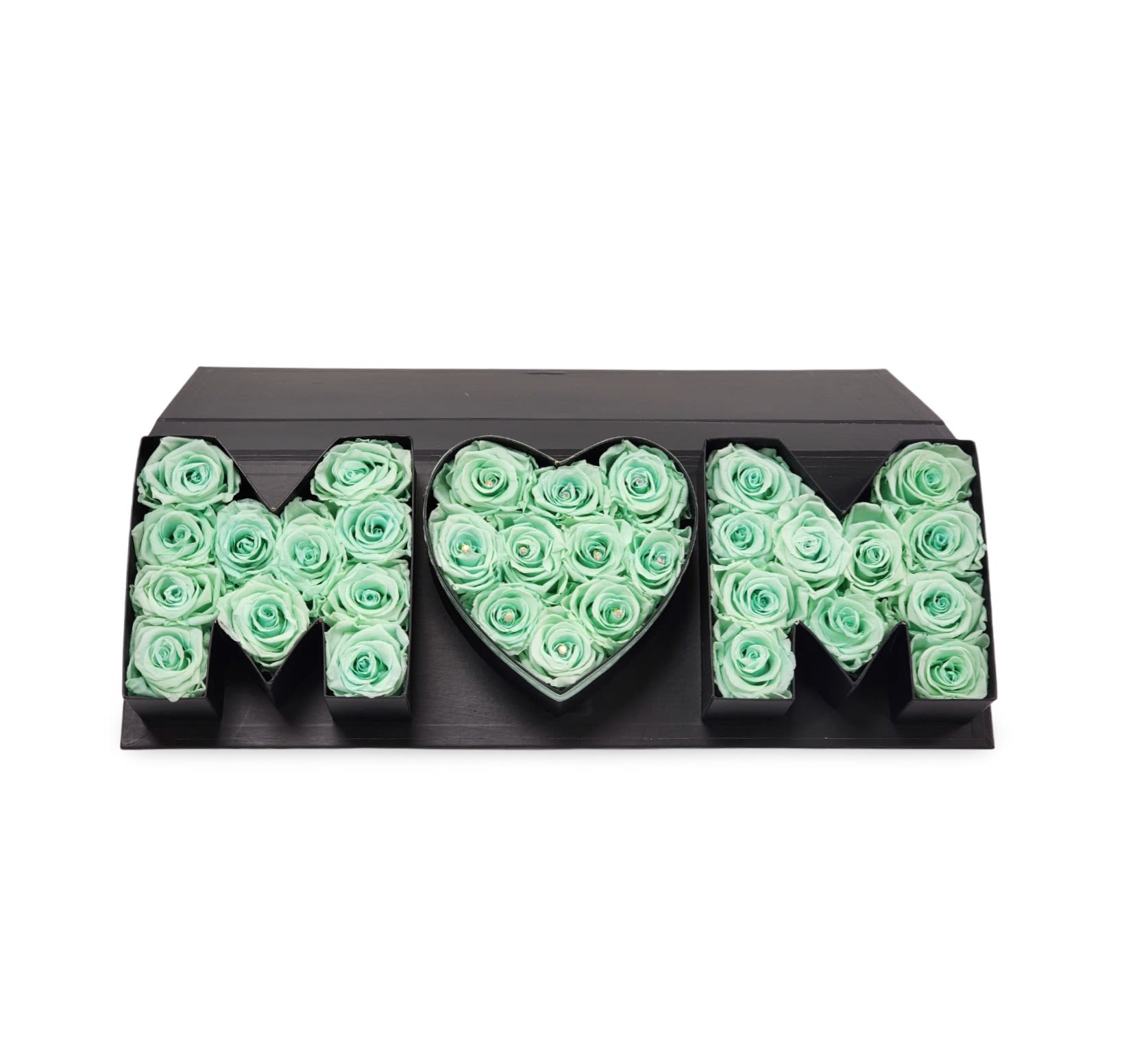 MOM Love Box – Mint Edition MOM Love Box – Mint Edition - Bold, modern, and unforgettable—our MOM Love Box – Mint Edition is made with stunning preserved mint colored roses arranged in sleek black letter-shaped boxes that spell out “MOM,” with a heart at the center. These preserved blooms offer lasting beauty without the need for water or maintenance, making it a gift she can enjoy for months to come. A perfect choice for Mother’s Day, birthdays, or any moment that deserves a special “thank you” to Mom.