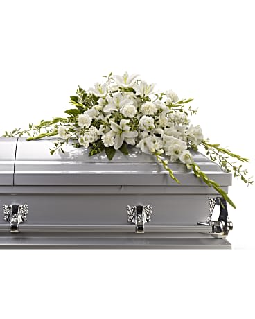 Bountiful Memories Casket Spray - Matching luminous all white flowers and delicate garden greenery is an elegantly simple way to lend serenity and quiet strength to the bereaved during a time of great reflection, and pay tribute to the deceased with affection and grace. Flowers such as pure white oriental lilies, gladioli, carnations and stock blend with fragrant greens to create a beautiful crescent-shaped half-casket spray. Orientation: N/A  SUBSTITUTION POLICY – Always deliver the freshest flowers! Please note the bouquet pictured reflects our original design.  If the exact flowers or container in this arrangement are not available, our local florists will create a beautiful bouquet with the freshest available flowers.