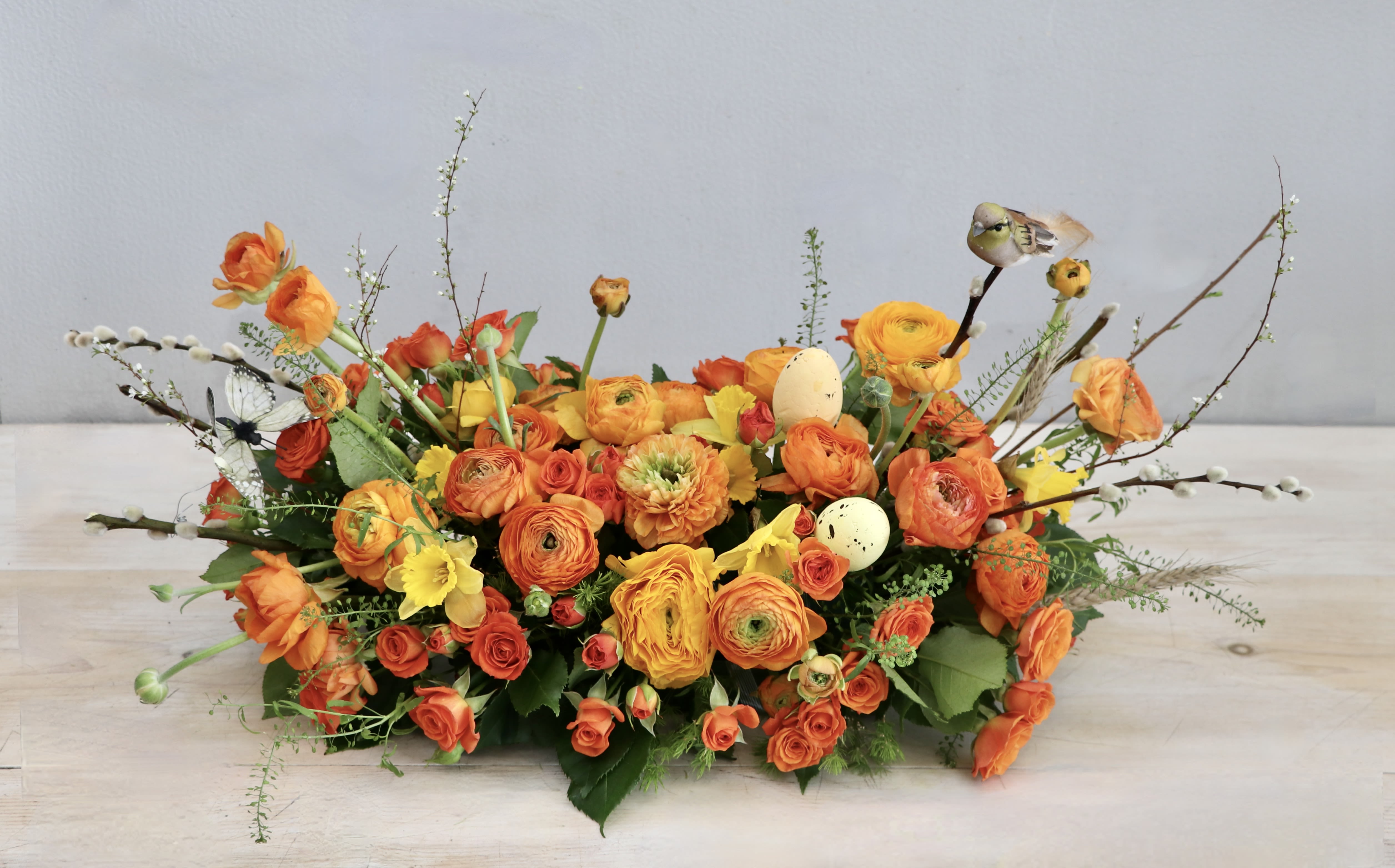 Easter Sunday Centerpiece - My Glendale Florist  - Celebrate Easter this year with this beautiful centerpiece arrangement. Its filled with some of our favorite spring blooms; ranunculus, daffodils, and spray roses. The photo shown is in the standard size, don't forget to upgrade for more blooms! 