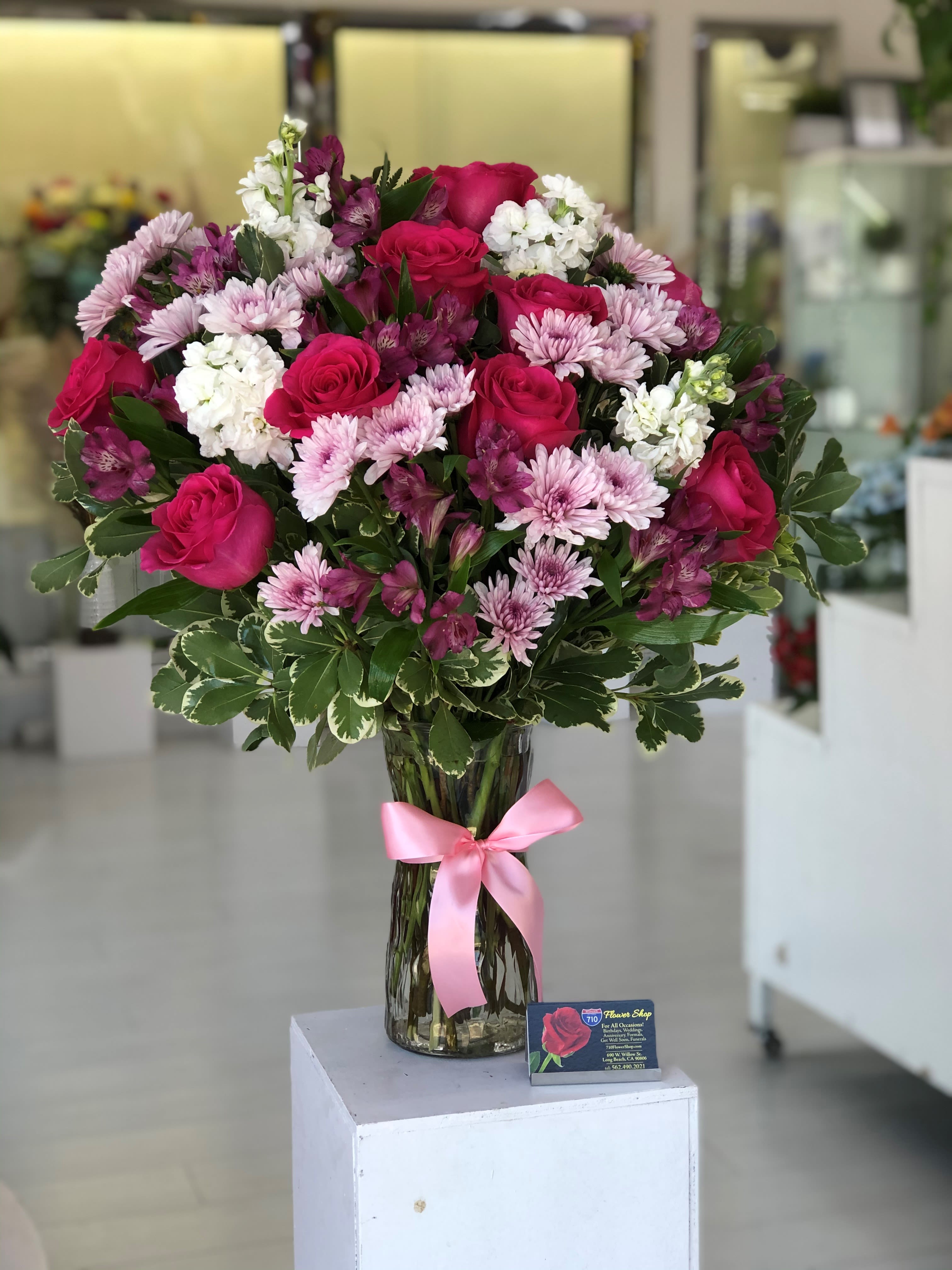 Blush Elegance - This bouquet features a lovely blend of pink and white flowers, with vibrant roses as the centerpiece. Flowers included: Roses, alstroemerias, cushion pompon, and stock!  If some flowers and/or the vase are not available there will be minor substitutions. 