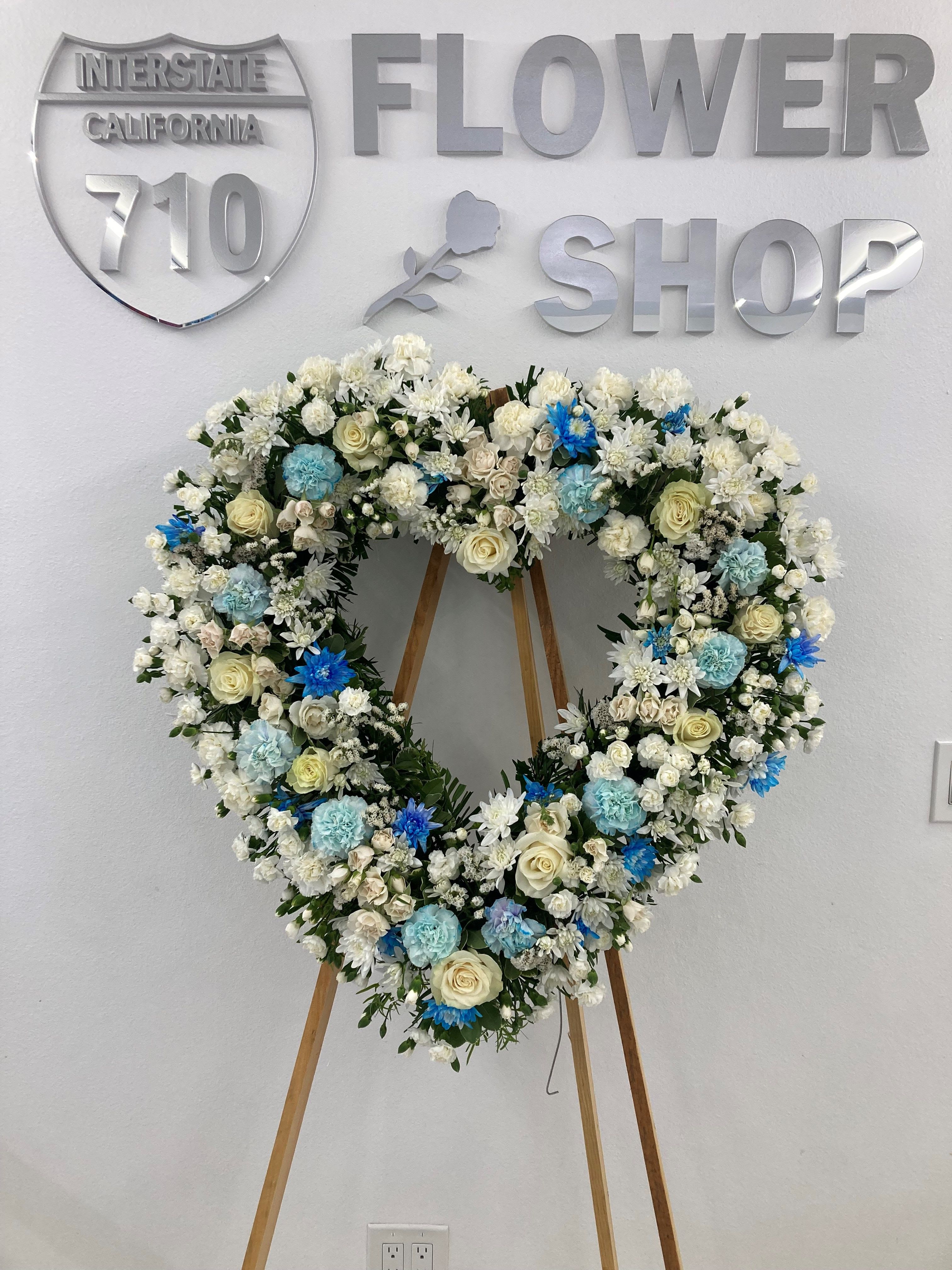 Heavenly Peace - This heart-shaped wreath features a serene mix of blue, white, and soft cream flowers.  Substitutions: If some flowers and/or the vase are not available there will be minor substitutions.  