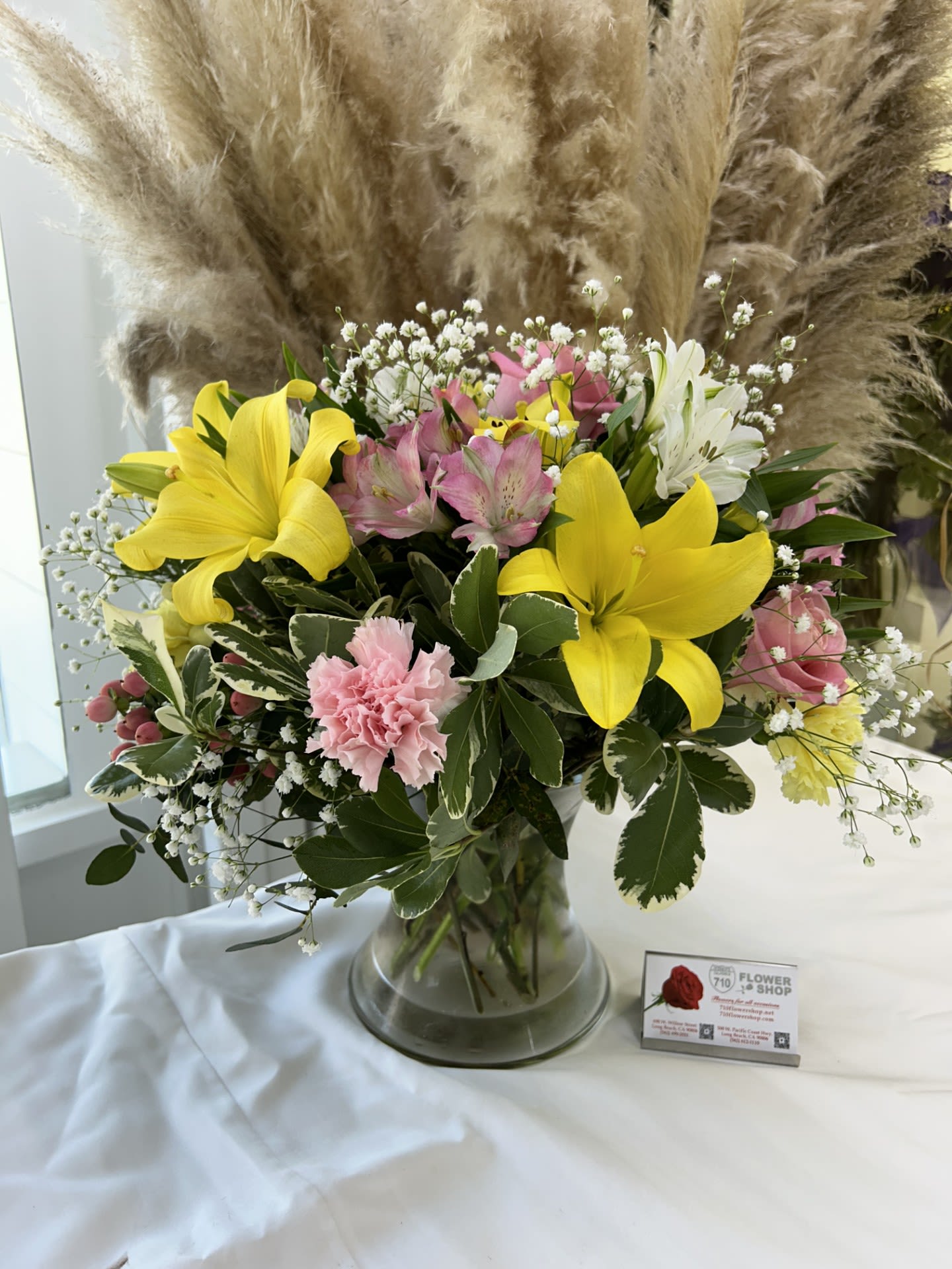 Sunshine Bliss - This arrangement with its bright yellow lilies and soft pink accents exudes a cheerful, fresh vibe. Mixed flower bouquet.  If some flowers and/or the vase are not available there will be minor substitutions.  