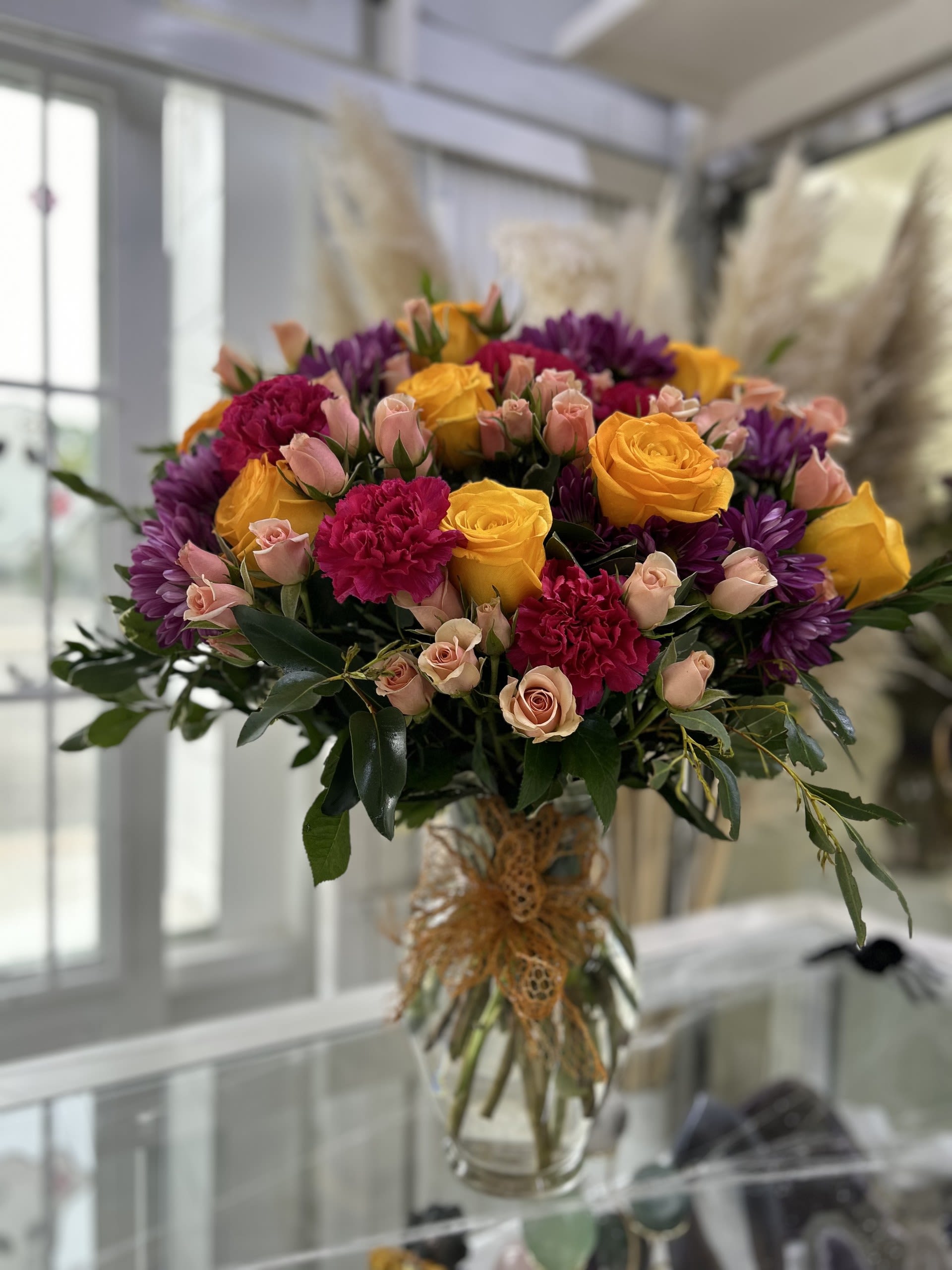 Radiant Harmony Radiant Harmony - The rich combination of colors creates a lively yet balanced feeling, perfect for adding a joyful and warm touch to any setting. If some flowers and/or the vase are not available there will be minor substitutions.
