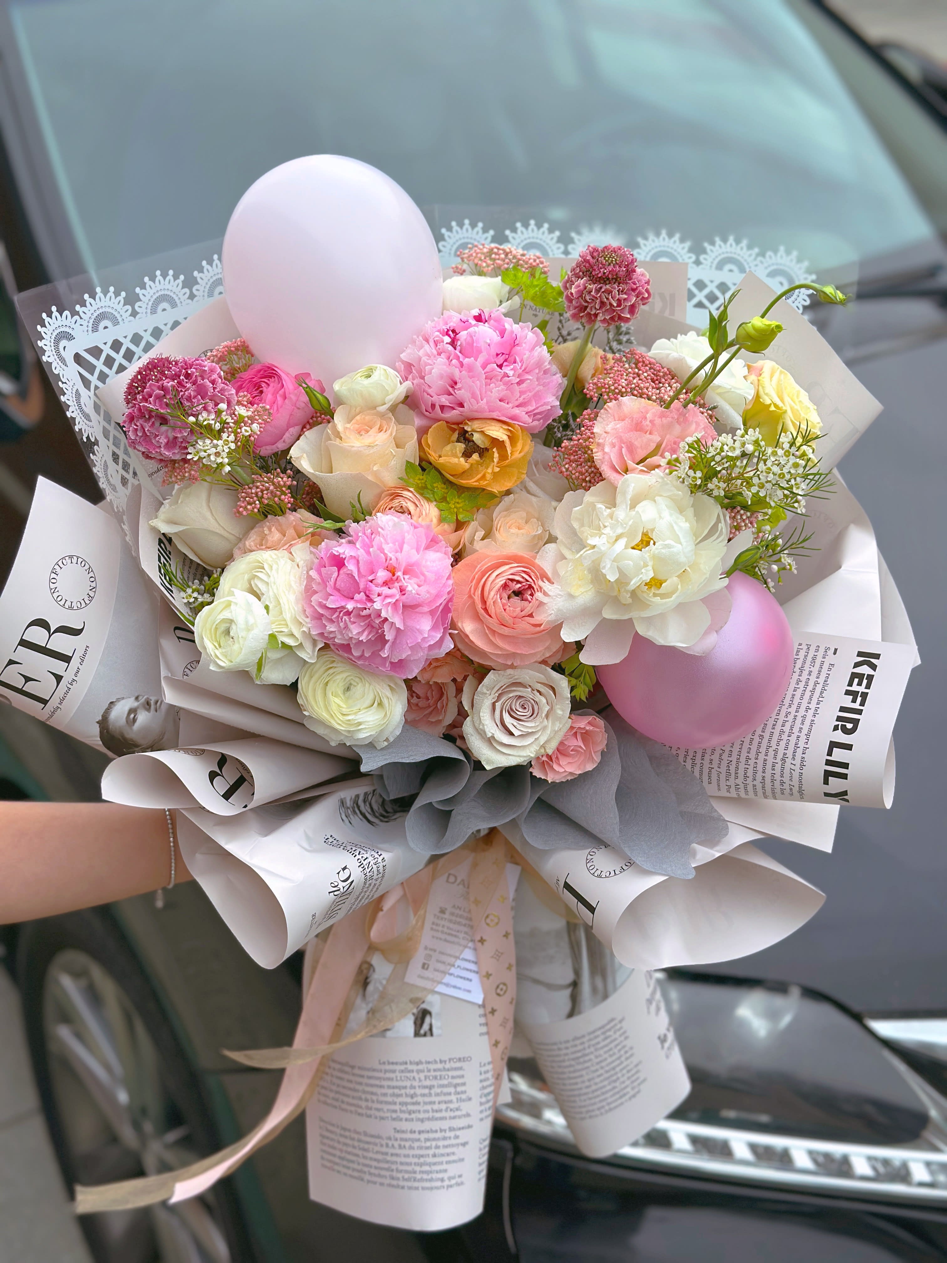 Buoyant mood - seasonal lush flowers mix with balloons, stylish paper wrap.