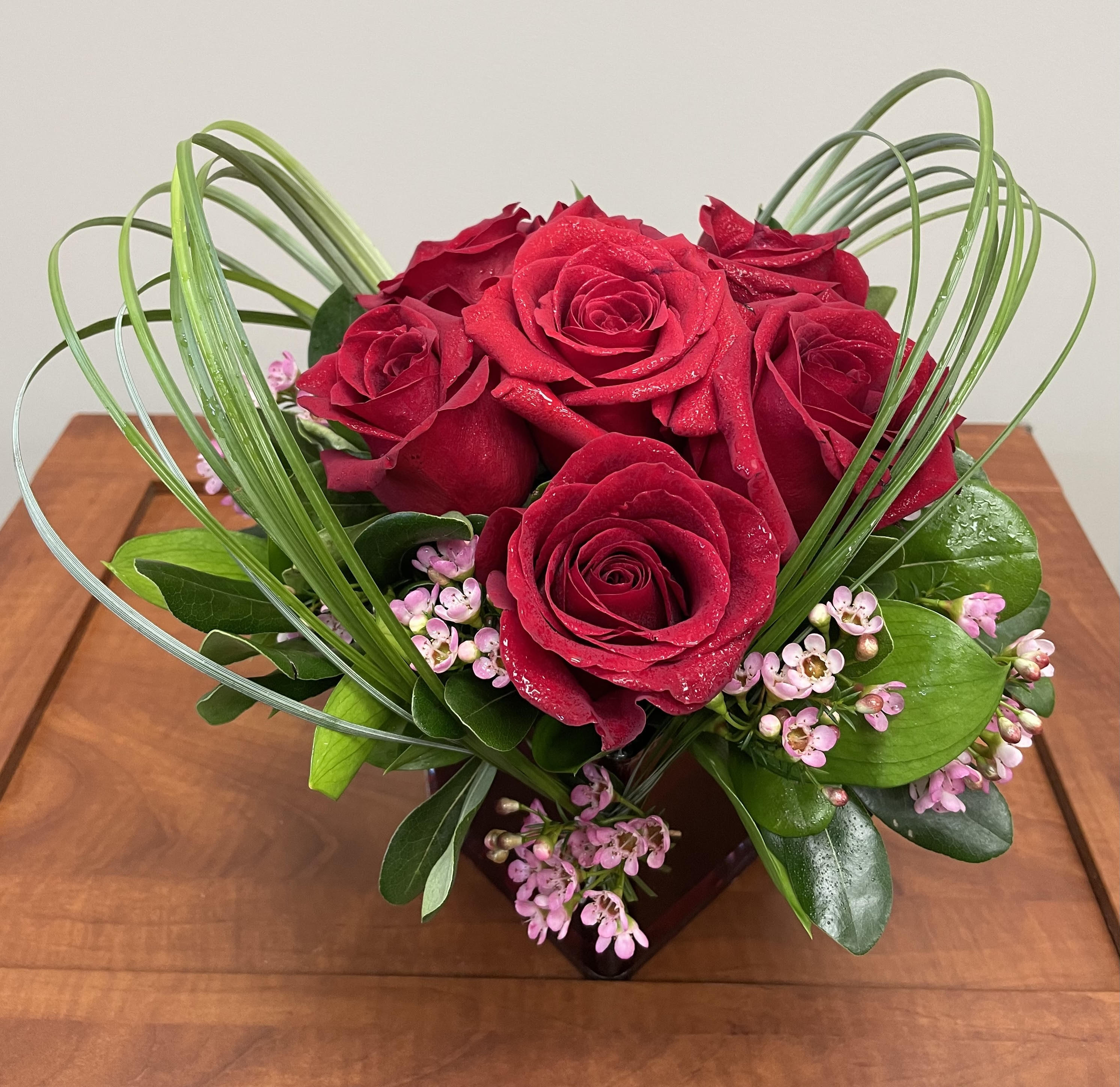 Sweet Thoughts - The perfect way to make a lasting impression - whether it's for a new love or to let your soul mate know they are still the one. A beautiful mix of 6 red roses, accented with bear grass, wax flower and seasonal greens. 