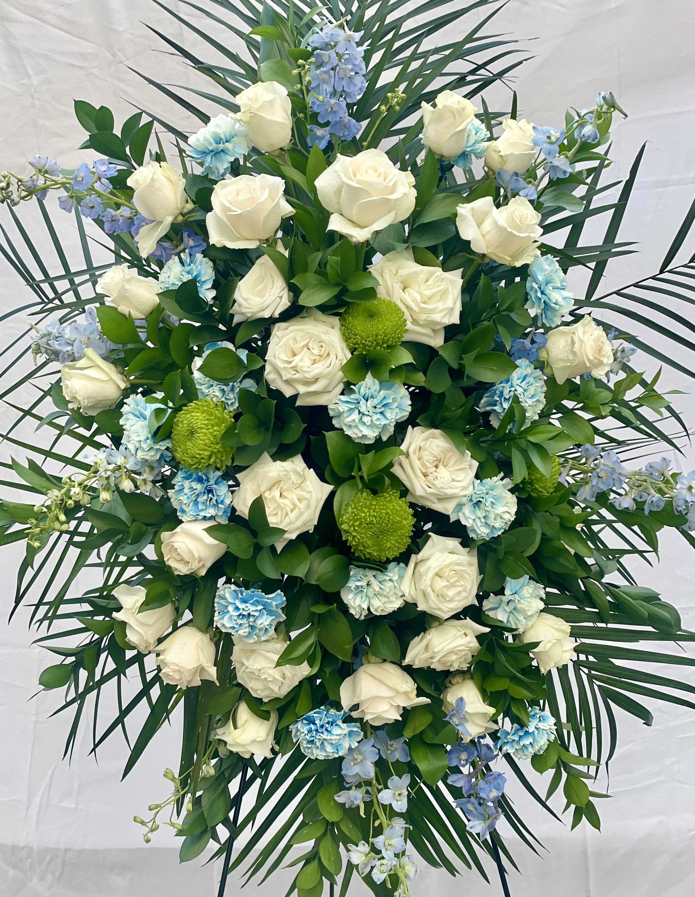 Sky's Embrace Sky's Embrace - A serene and heartfelt funeral spray featuring delicate blue flowers, symbolizing peace, tranquility, and the gentle embrace of the heavens. This floral arrangement offers a calming tribute, evoking the boundless sky and the eternal spirit, providing comfort and solace to those mourning. Perfect for honoring a loved one with grace and serenity.