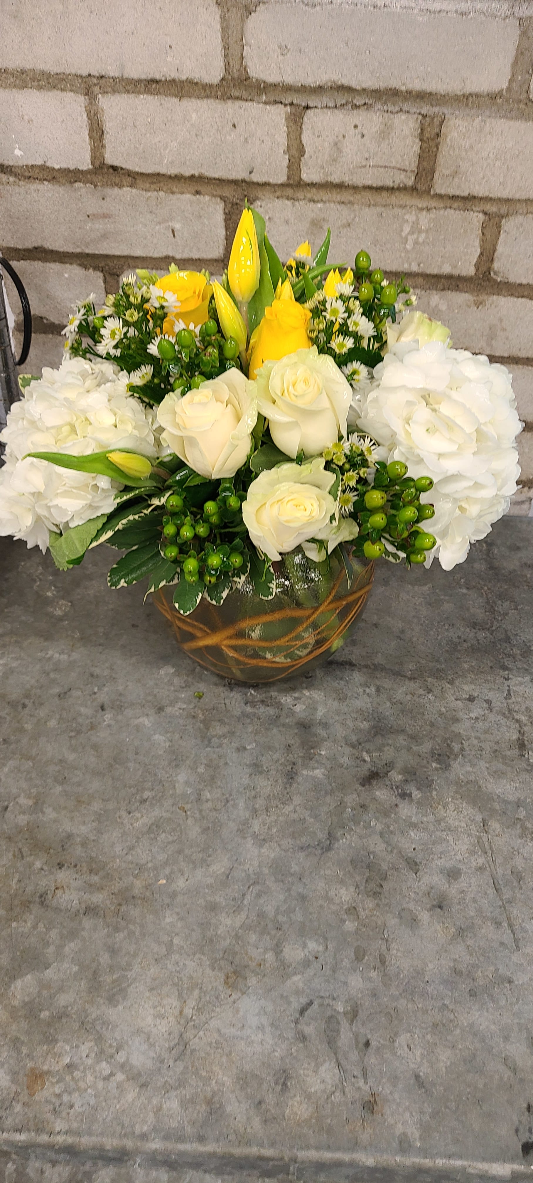 Bowl of charm by Kokee - Like the name say it is a round vase arrangement with yellow tulips and white hydrangeas  in a compact style gibing the expression of charm.