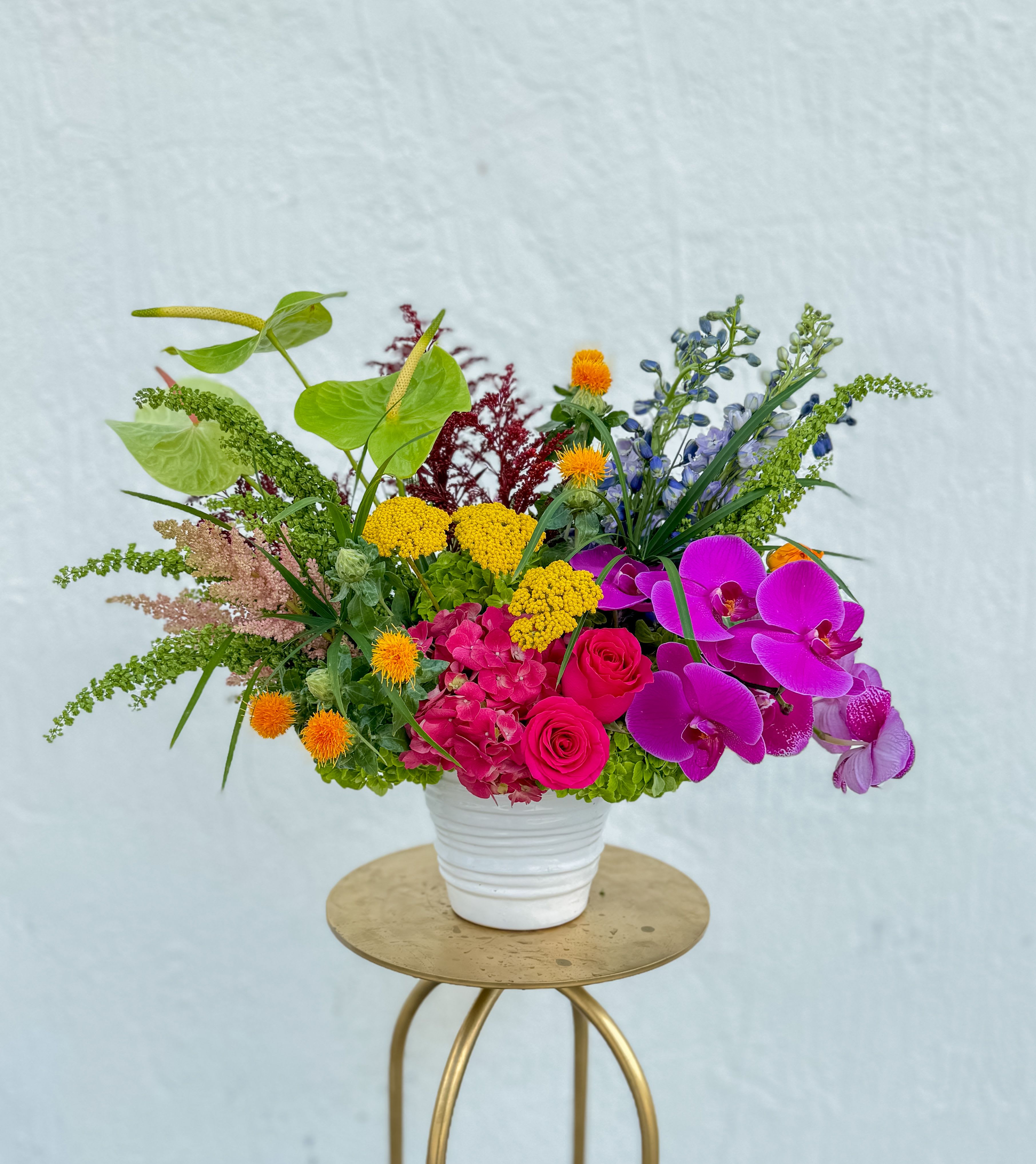 Grand Soleil - This stunning arrangement captures the warmth and vibrancy of a tropical paradise, with a lush combination of vivid blooms and exotic greenery. 