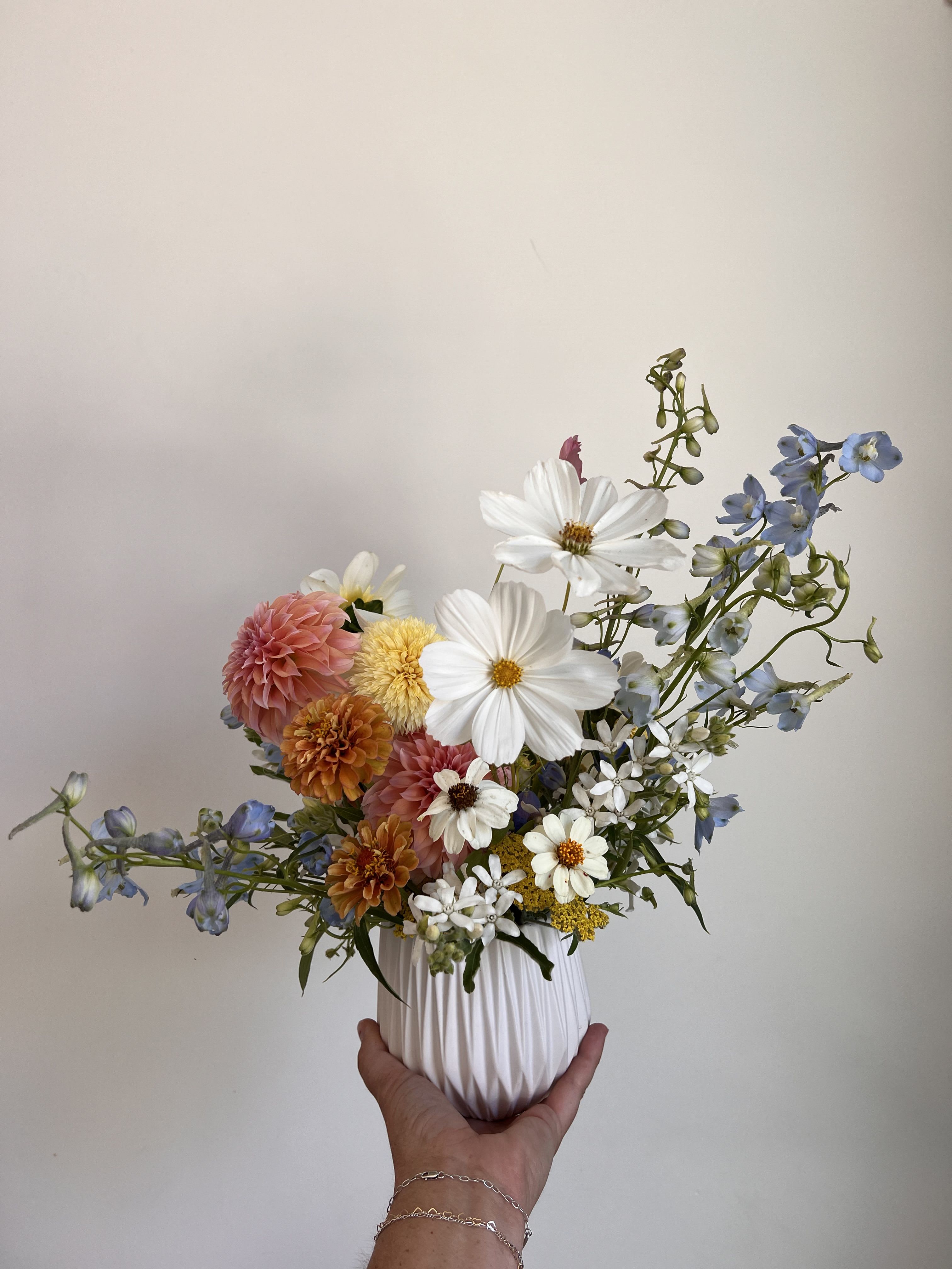 Sunset & Sea Flower Arrangement Sunset & Sea Flower Arrangement - Let nature’s most beautiful moments bloom in your space. This striking arrangement features lush dahlias, airy cosmos, and elegant delphiniums in a palette inspired by the vibrant hues of sunset and the calming tones of the ocean. Warm corals, soft peach, and golden amber blend seamlessly with cool blues and cloud white, creating a visual harmony that feels both romantic and refreshing. Perfect for birthdays, celebrations, or simply brightening someone’s day, "Sunset & Sea" brings a dreamy, coastal charm to any room. Handcrafted with seasonal blooms and arranged with care, it’s a reminder of golden evenings and waves crashing softly at dusk. Available for local delivery — each arrangement is unique and designed with fresh, seasonal flowers. Newport Beach florist delivering to Costa Mesa, Laguna Beach, Huntington Beach, Santa Ana and Irvine.