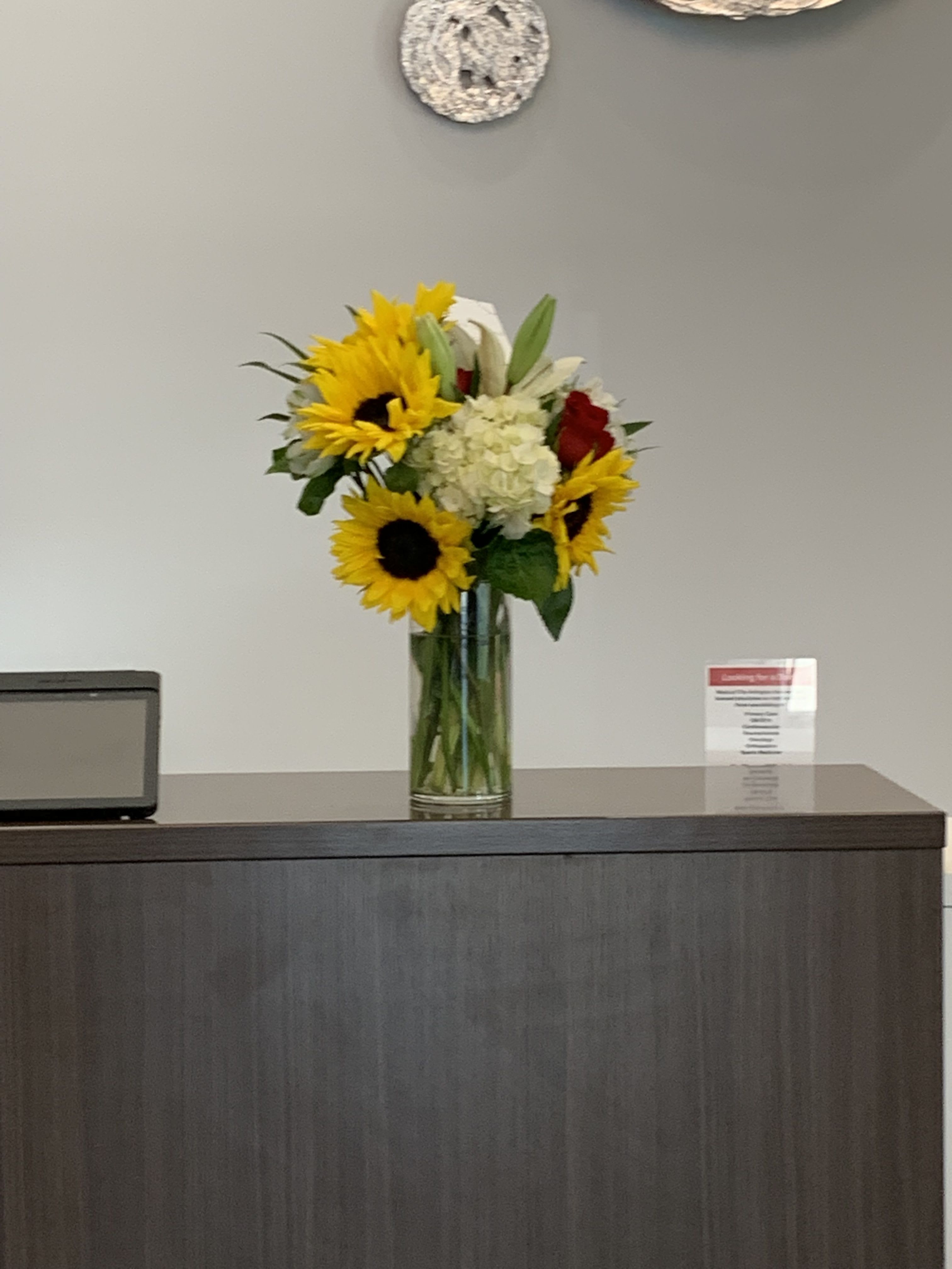 Simplicity Blooms Simplicity Blooms - In this arrangement sunflowers and hydrangea with a few of their friends, brighten up anyone’s day in the simplest yet most beautiful way. Picture is of standard arrangement.