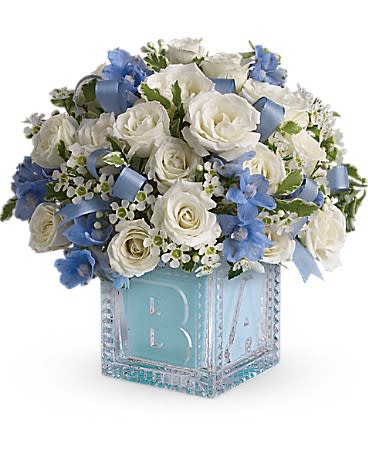Baby's First Block by Teleflora - Blue Baby's First Block by Teleflora - Blue - Celebrate the coolest baby boy on the block's arrival with this charming glass baby block that arrives chock full of pretty flowers. Perfect for baby showers too! The glass block will make an adorable display piece for years!