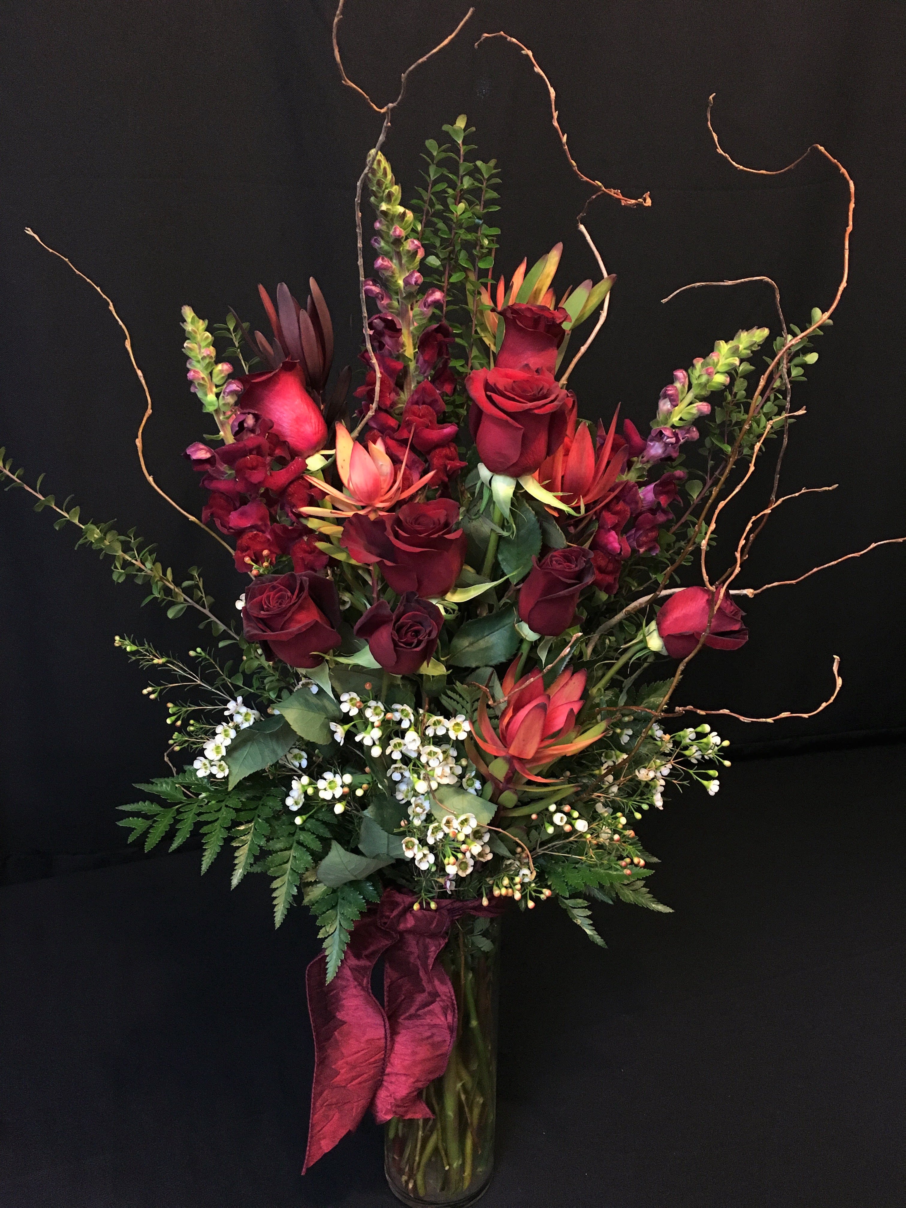 8 Rose Cylinder with Safari Sunset and Snapdragons - Color May Vary - Rose color may vary. Unique and modern design for those who want a more creative rose bouquet.  Tall and elegant with curly willow branches.  Filler flower and colors may vary.  See photo 2. Long stem premium roses. Color preferences will be taken into consideration but cannot be confirmed without a call into our shop. Please put them in the Comments section. 8 Gorgeous Premium Roses -   This tall arrangement comes with Everything!   Over 2 feet tall!  Items  and rose may vary but normally includes premium greenery and branches plus filler flowers and Safari Sunset. Order at least 3 weeks prior to Valentines for closest match.   