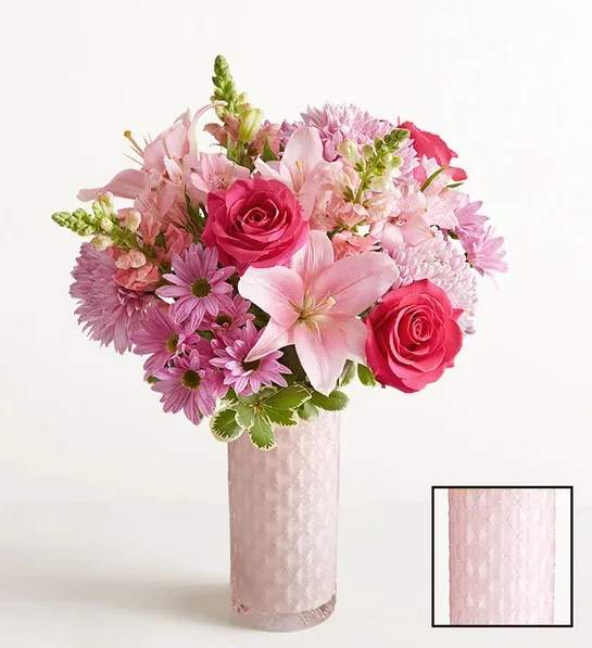 Mother’s Embrace™ Bouquet - Thank Mom for a lifetime of comforting hugs with our Mother's Embrace™ Bouquet. Lovely pink and lavender blooms are hand-designed in a pink glass vase with subtle sparkle and pattern.