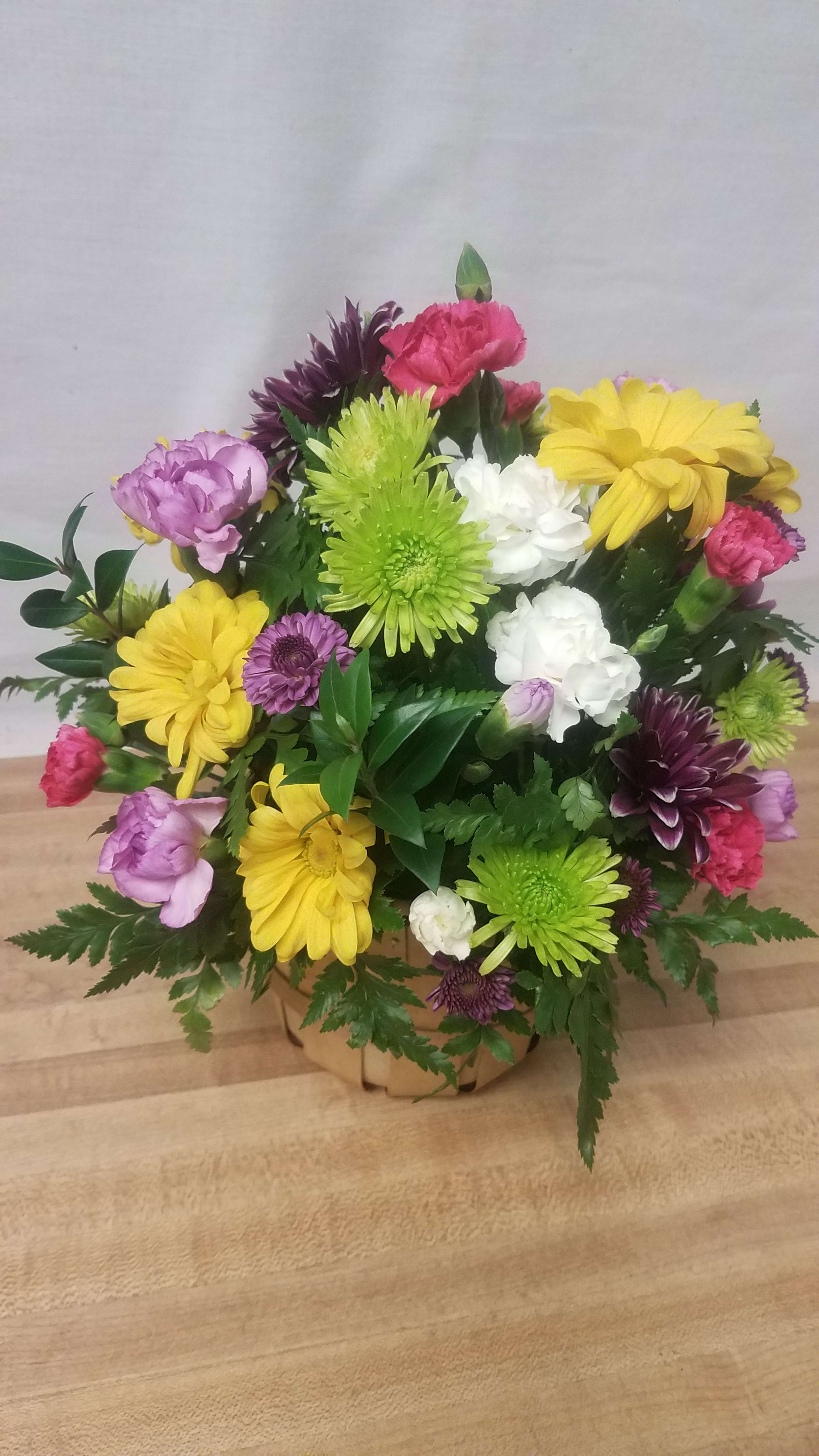 A Touch of Spring - Our basket made with the colors of spring to brighten anyone's day.   Each unique arrangement is individually crafted with the freshest flowers available that day.  (Flowers and colors will vary)