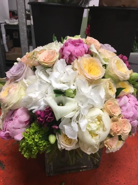 Anitas Reserve Anitas Reserve - This incredible arrangement is sure to please. Made in a glass cube with Leaf lined and flowers are nothing but the best, featuring Pastel color garden roses , whites and yellows, with Dutch hydrangea , white and pink peonies. Measuring about 17 inches tall and 14 inches across.