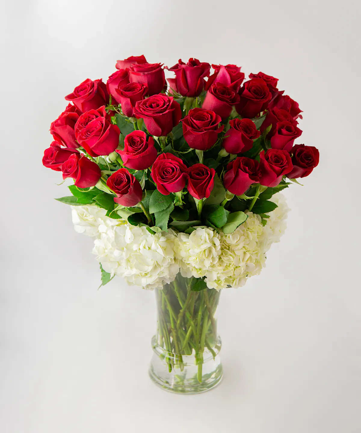 LAVISH - 35 or 75 LUXURY LONG STEM ROSES - Lavish — to bestow something in generous or extravagant quantities upon—  that’s exactly how the receiver of this out-of-this-world presentation will feel! Overflowing with love, and 75 gorgeous long stem rose blooms exquisitely arranged with ivory hydrangeas in a tall glass vase creating the perfect circle, the symbol of eternity. Let them know you’ll love them forever.