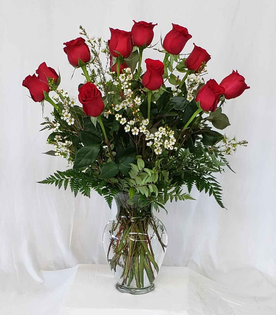 Dozen Red Roses (or any color of choice) V1-C - Dozen Red Roses or in color of choice with greens and accents in a clear glass vase.