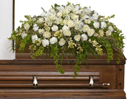 TRANQUILITY CASKET SPRAY FUNERAL FLOWERS - There’s something about white flowers that exude a sense of purity and peace. We have included a variety of white flowers in this particular arrangement: roses, carnations. snapdragons, Fuji mums, Asiatic lilies, and more. Allow this arrangement to reflect precious memories and bring you and your loved ones peace.