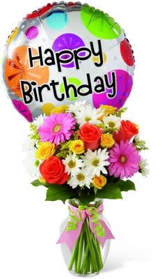 Birthday Cheer Bouquet - The Birthday Cheer Bouquet is set to celebrate with its bright, beautiful blooms wishing your special recipient every happiness on their big day! Coral roses, yellow spray roses, hot pink gerbera daisies, white traditional daisies, solidago and lush greens are perfectly arranged in a classic clear glass vase tied with pink satin and green chenille ribbons. Arriving with a mylar balloon exclaiming, &quot;Happy Birthday,&quot; this bouquet will add to the warmth and happiness of their birthday festivities.