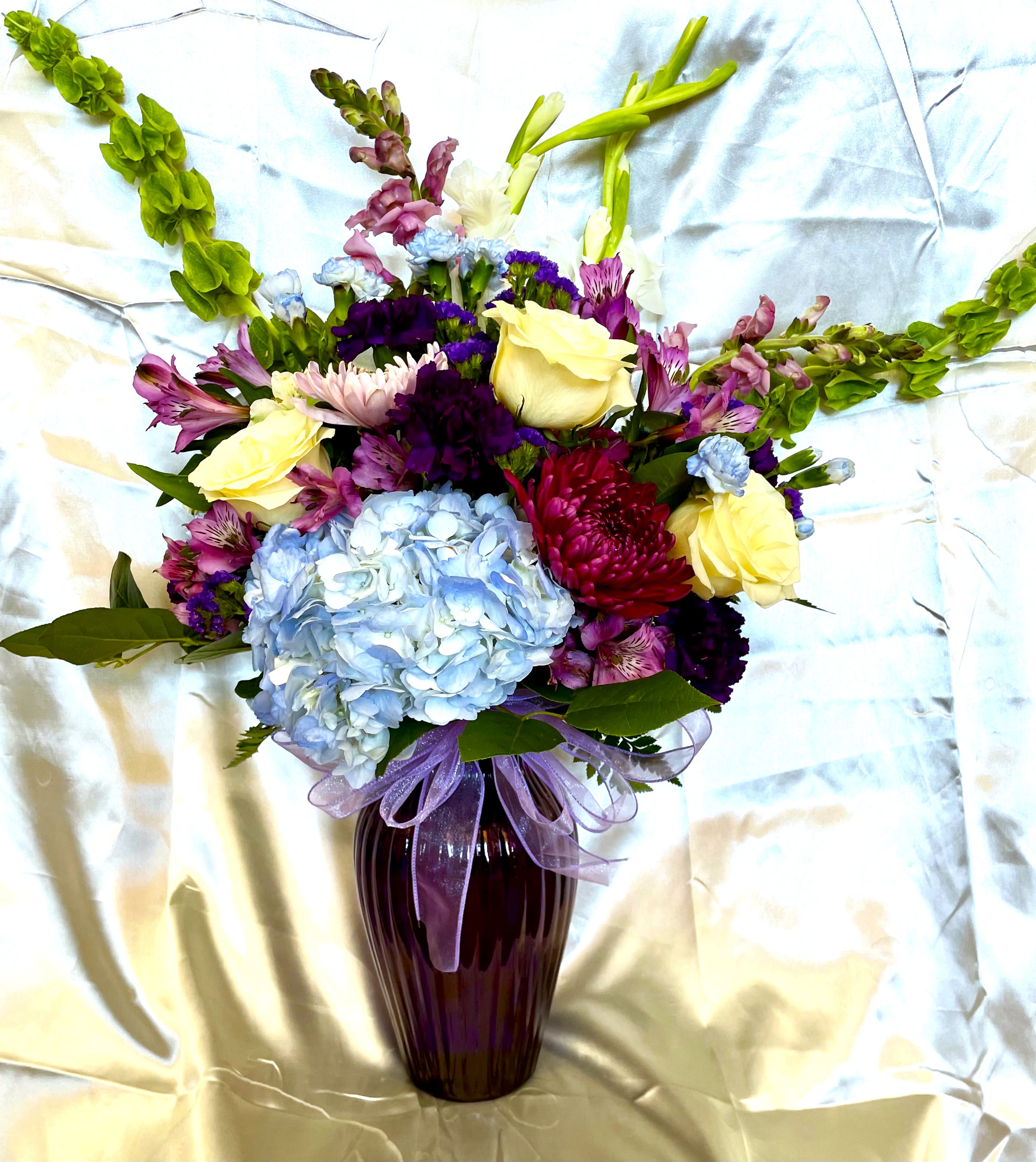 Misty Blue Custom Arrangement Misty Blue Custom Arrangement - Elegant and sophisticated arrangement, with lot's of blue and purple flowers. Picture is of a standard arrangement. Make it more special with a deluxe or premium arrangement.