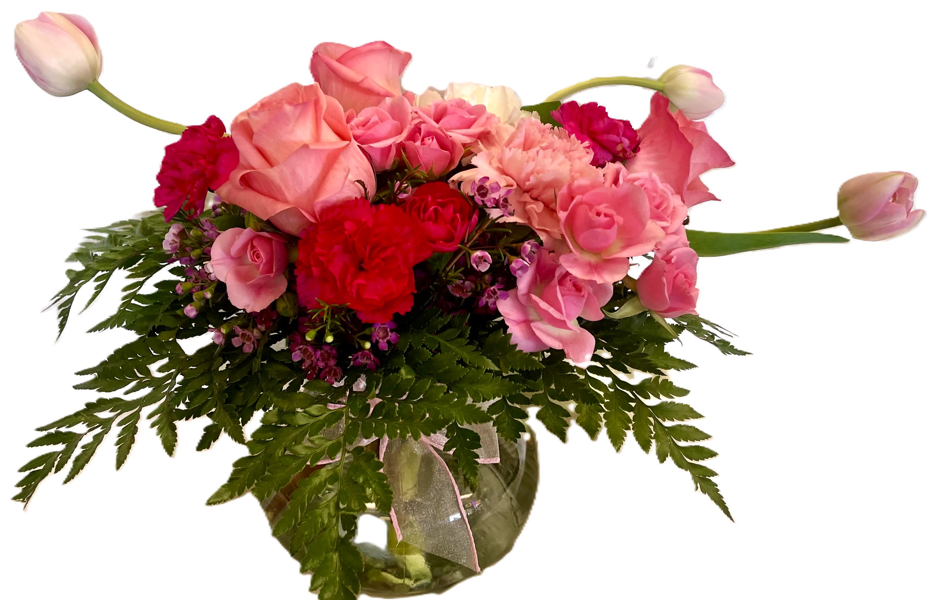 Pretty in Pink Pretty in Pink - Lovely pink themed arrangement. Made of pink tulips, pink wax flower, light pink roses, pink mini carnations, white carnation and greens in a glass vase.