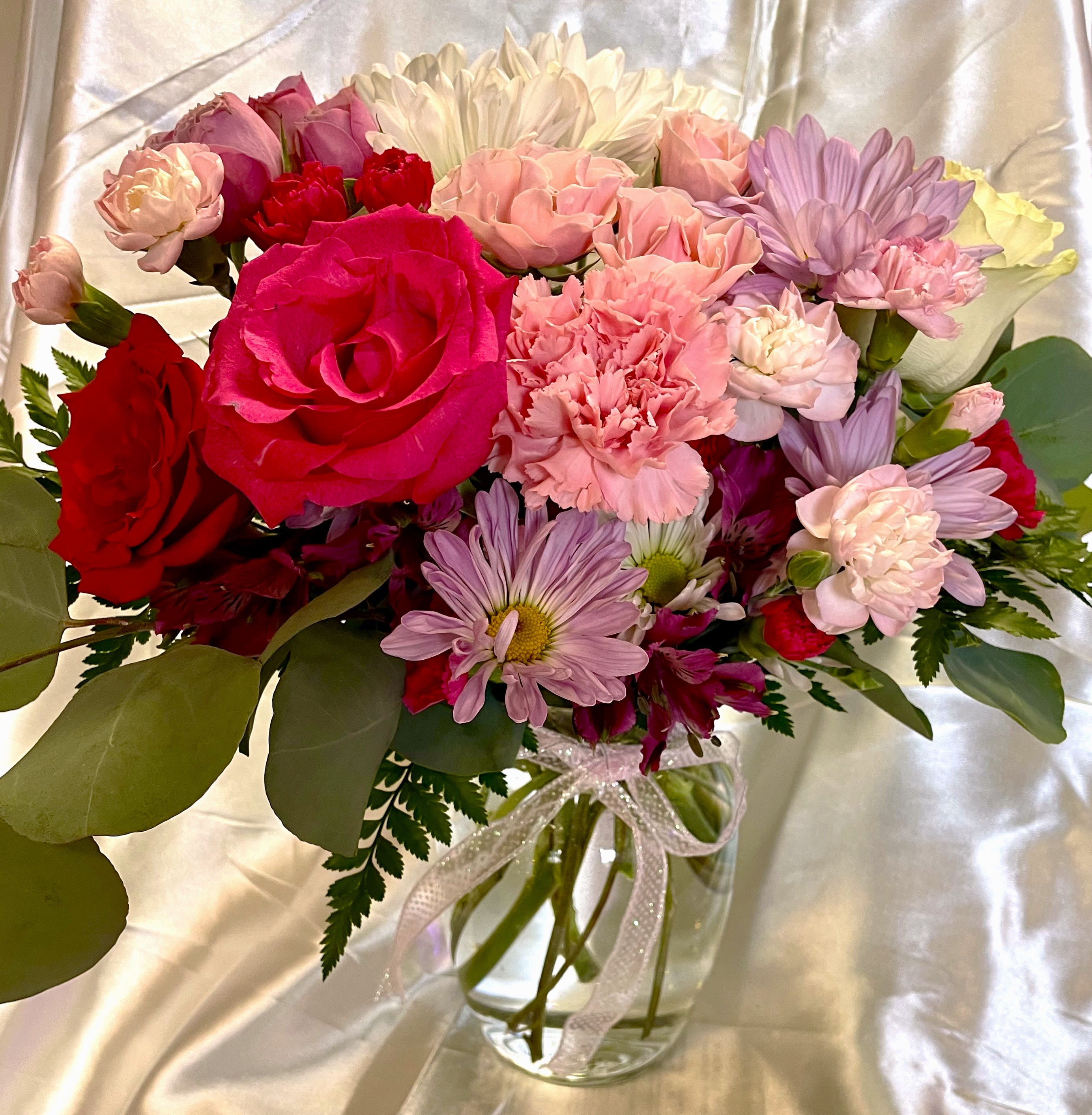 Sweet Thoughts Bouquet Sweet Thoughts Bouquet - Send a Sweet Surprise in the form of pink and white flowers. Hot pink spray roses, pink mini carnations and white daisy pompons are sweetly arranged in a clear vase and trimmed with pink ribbon. Approximately 7H" X 7W"