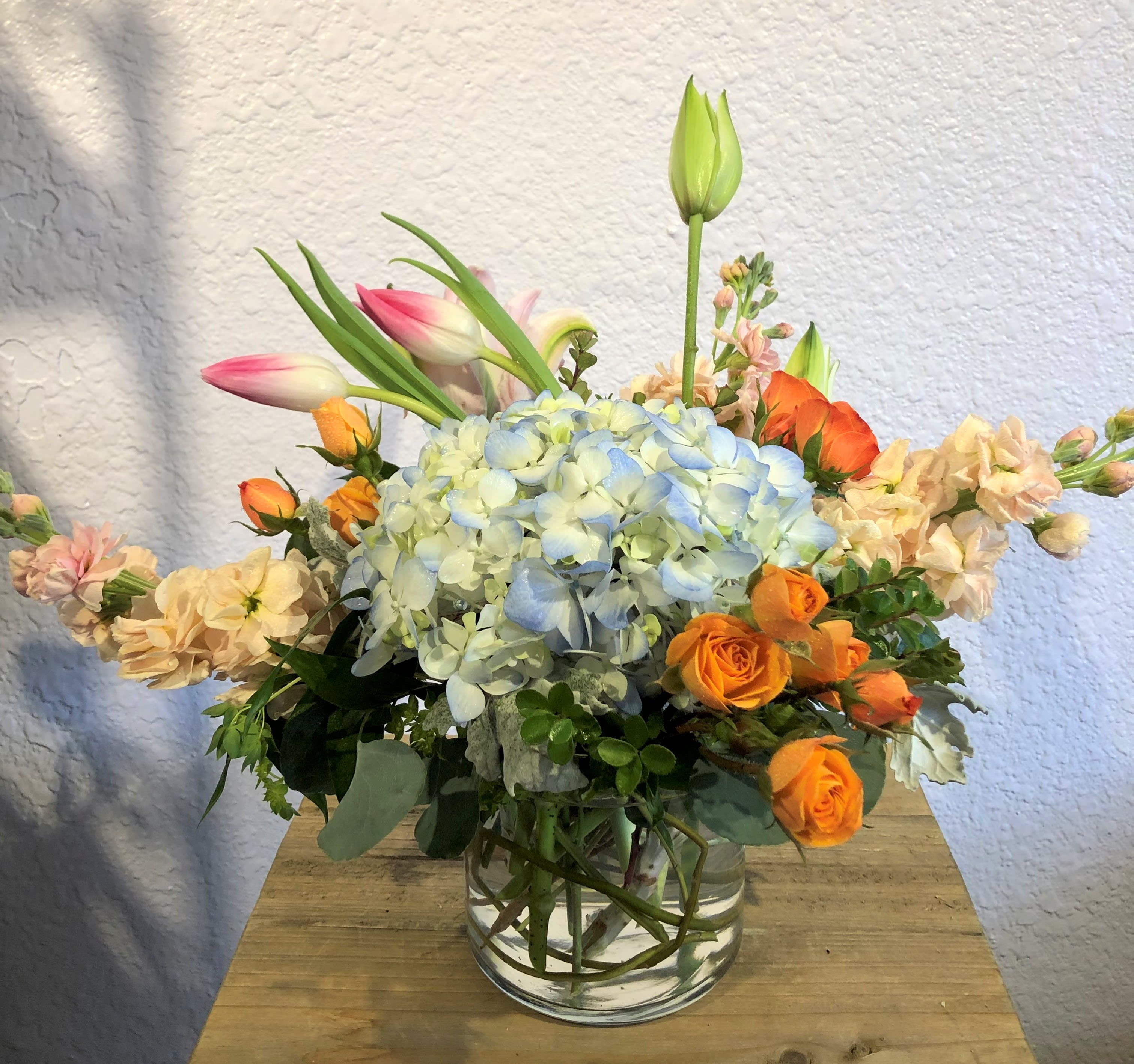 Colorful Laughter Colorful Laughter - A bright & cheerful mix of multi-colored spring flowers. Send as a birthday, thank you or to simply to brighten some one's day! Pictured is Hydrangea, Stock, Lily, Tulips, and Spray Roses. Your arrangement will be designed in the style shown, but flowers and containers may be different if not available.
