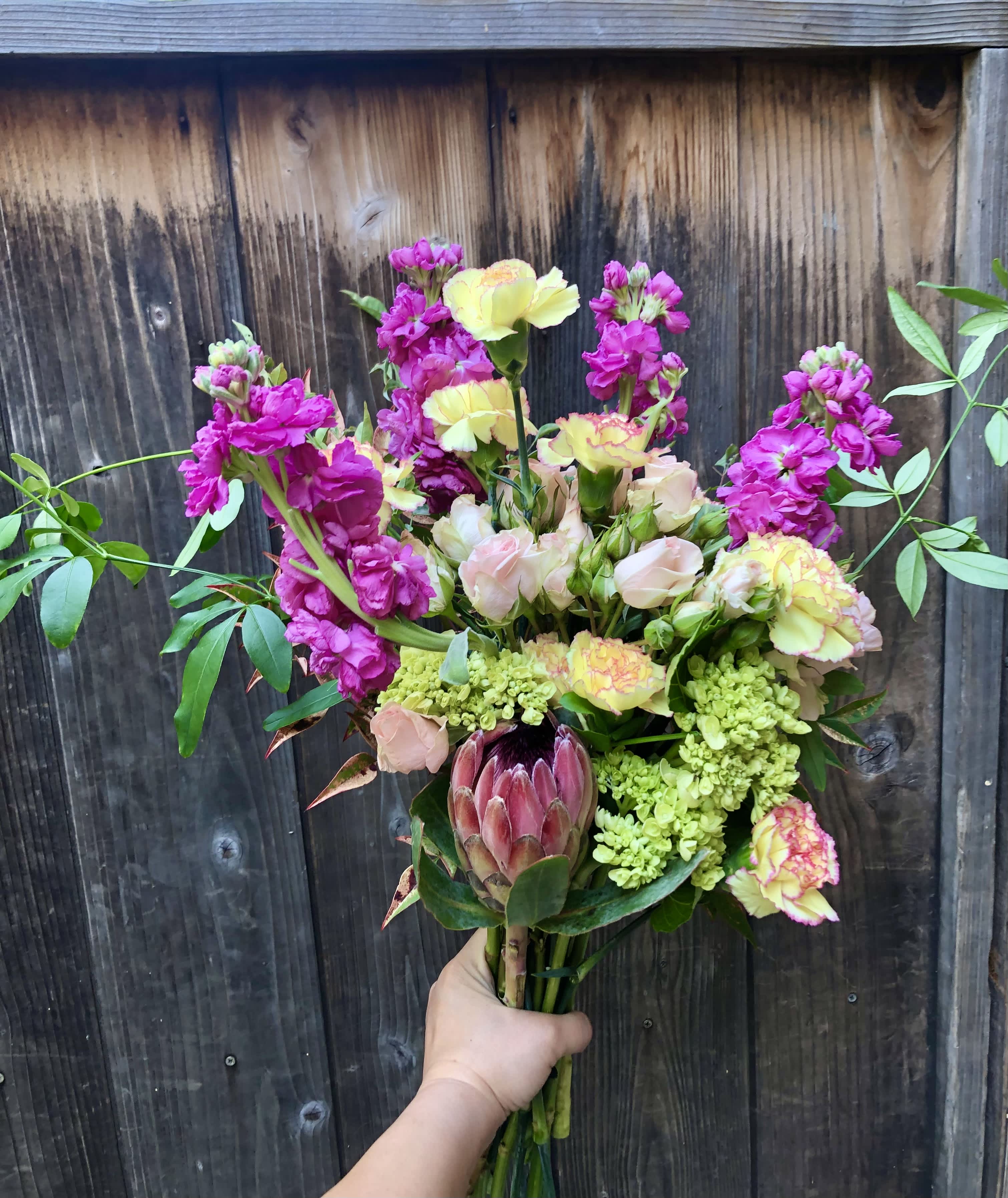 Neon summer bouquet Neon summer bouquet - Put on your sunglasses because it's getting bright! This neon summer bouquet is made with protea, stock, carnations, spray roses, and hydrangea.