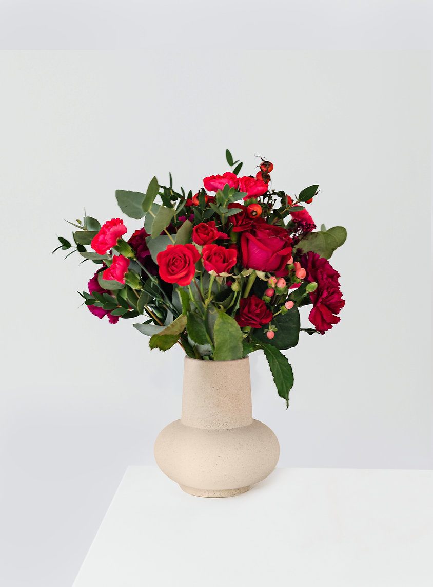 A Ruby Celebration A Ruby Celebration - A monochromatic medley of mini carnations, spray roses, and half a dozen single stem red roses, and hypericum.