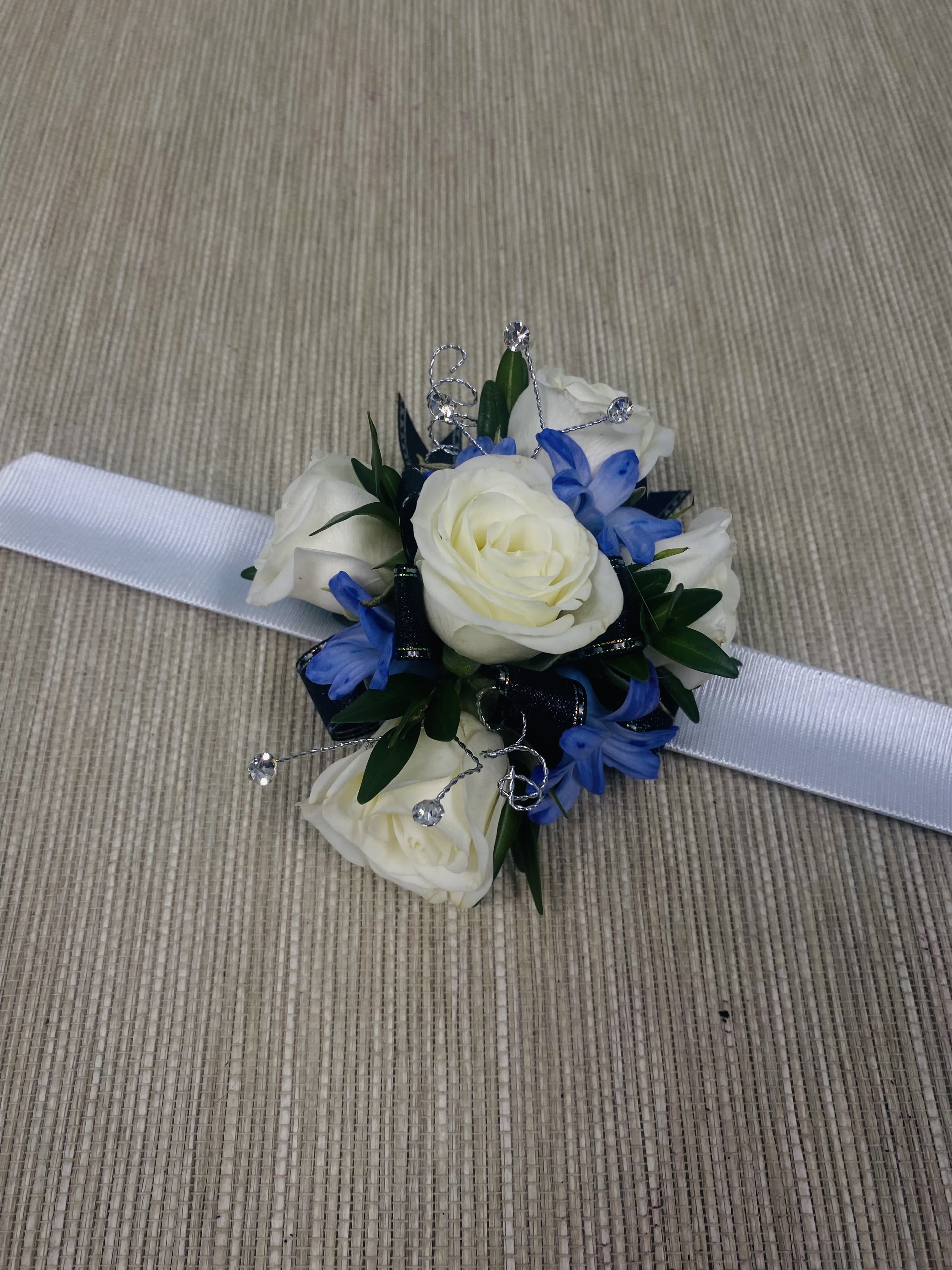 Royal White Corsage Royal White Corsage - A boutonniere containing white spray roses with a touch of purple.