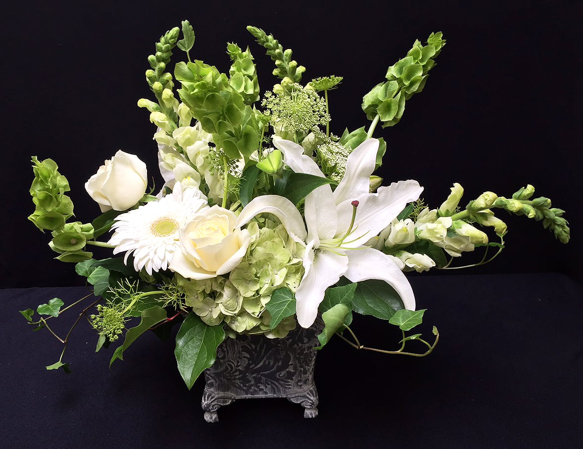 Calm AF11 - This calming arrangement of all white and green seasonal flowers, roses, lilies and greens is perfect for any occasion. NOTE: Container may vary, but overall look, quality and value will always be spot on!