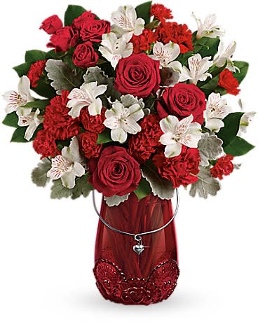 TELEFLORA'S RED HAUTE BOUQUET TELEFLORA'S RED HAUTE BOUQUET - Take her breath away with this passionate rose bouquet, presented in a keepsake glass lantern vase with beautiful lace detail and sparkling heart charm. This arrangement features red roses, red spray roses, white alstroemeria, red carnations, red miniature carnations, dusty miller, and lemon leaf. Delivered in a Red Haute Vase. Orientation: One-Sided