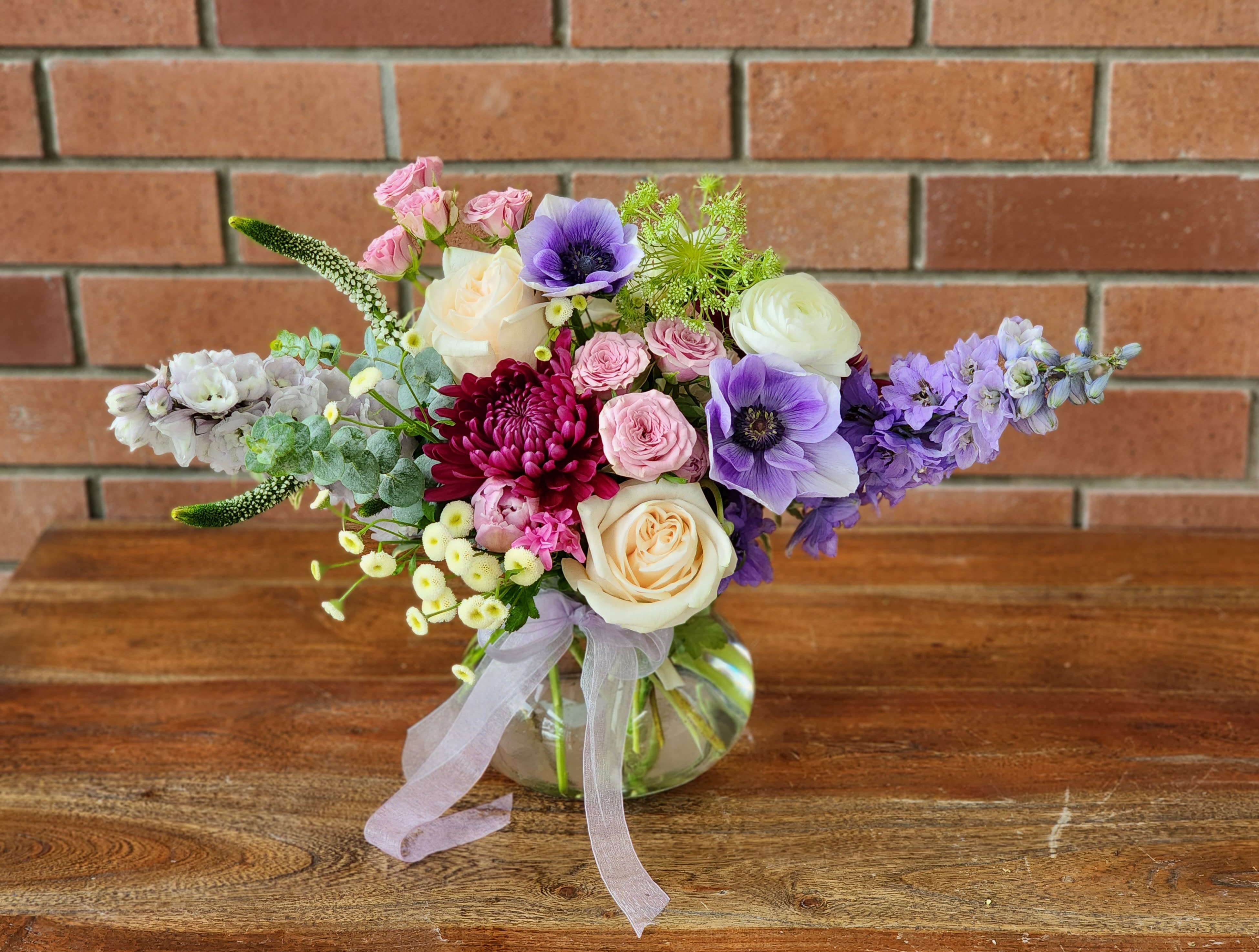 Periwinkle Fields Bouquet  - Shades of lavender and periwinkle flowers - delphinium, anemones, mums, micro mums, Veronica, garden roses and spray roses, ranunculus and Eucalyptus in a beautiful vase with periwinkle colored ribbons. 