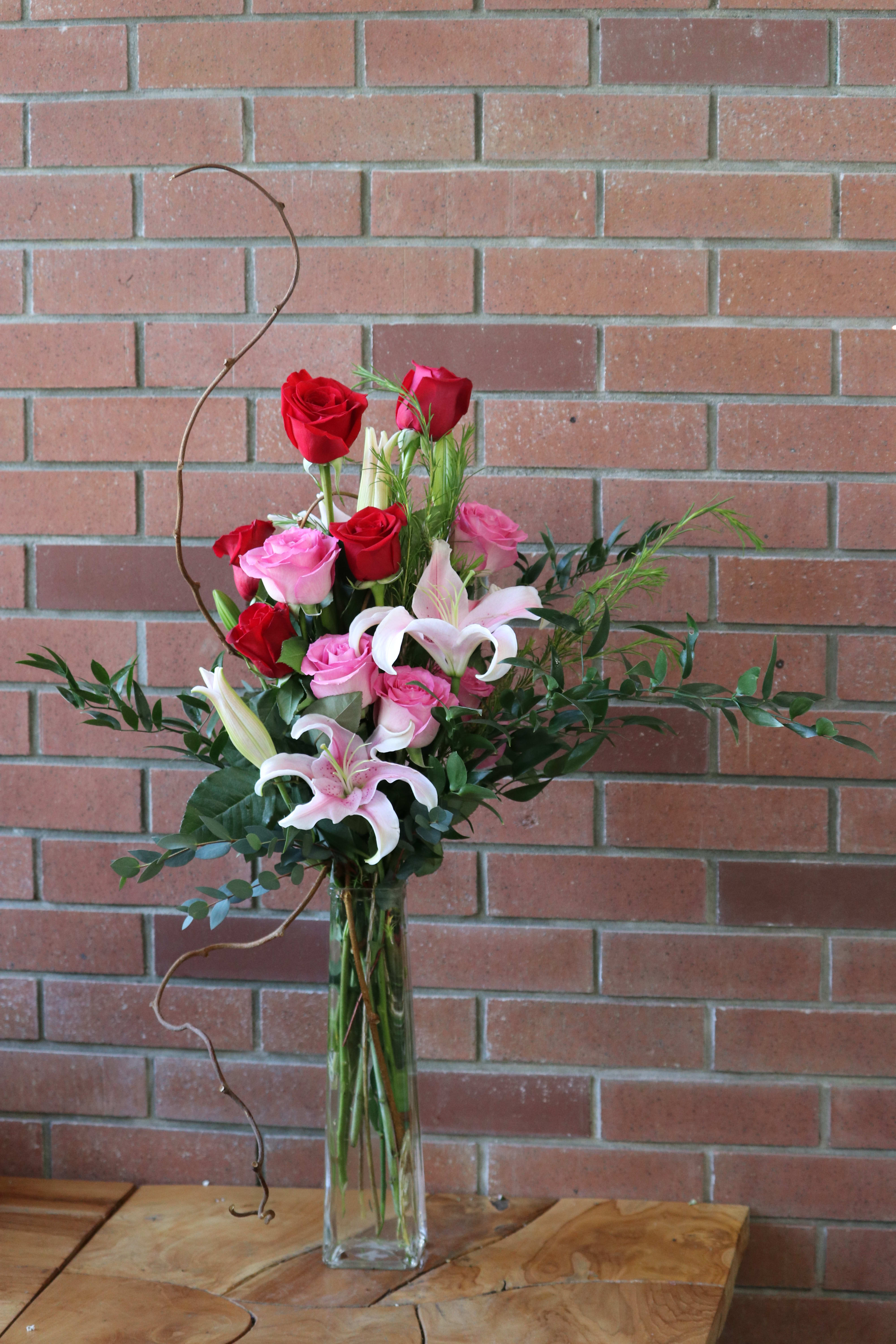 Classic Romance Bouquet Classic Romance Bouquet - For a special occasion, send our tall and elegant arrangement of fragrant lilies, roses, lush greenery and vines in a tall skinny vase.